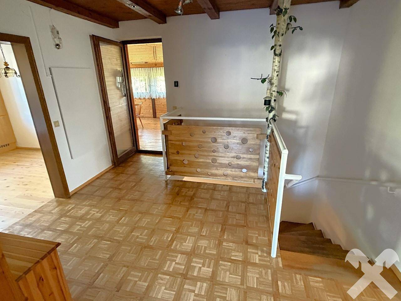 Geräumiger Flur mit Parkettboden, Holzvertäfelung und Zugang zu weiteren Räumen.
