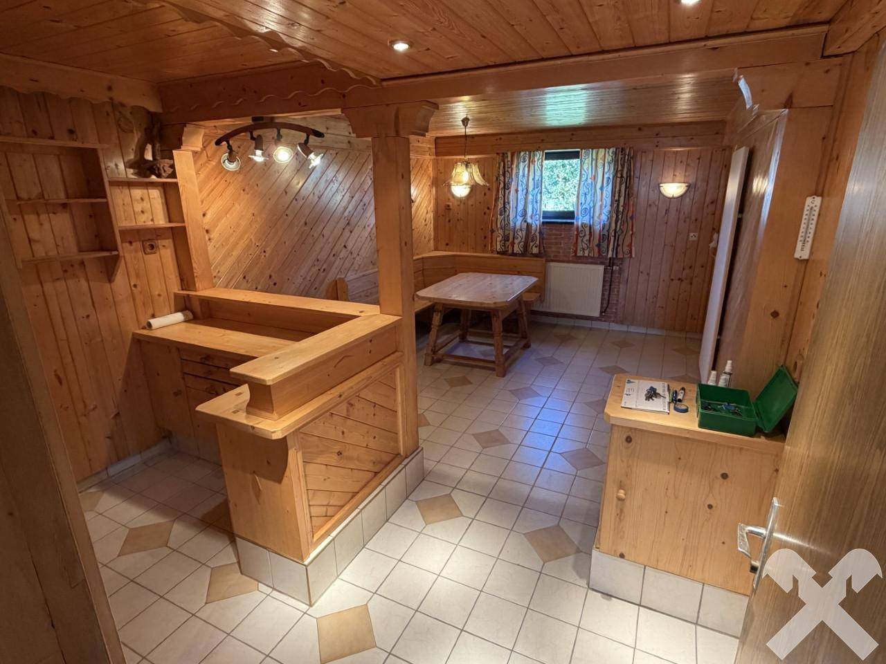 Rustikaler Wohnraum mit Holzvertäfelung, Bar und Essbereich im Landhausstil.
