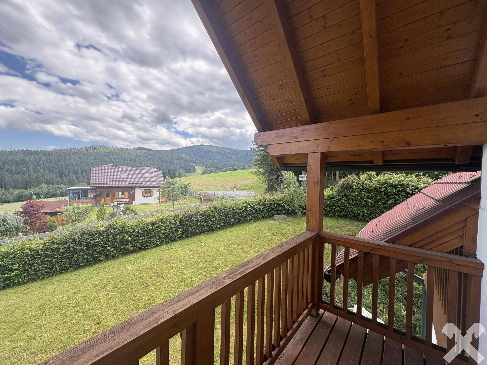 Weiterer Balkon mit weitem Blick über die grüne Hügellandschaft und ferne Berge.