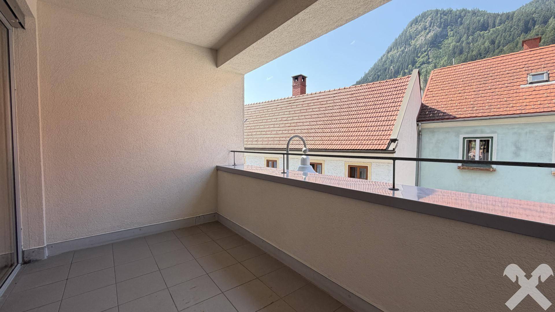 Überdachter Balkon mit Fliesenboden und weitem Blick auf die umliegenden Berge.