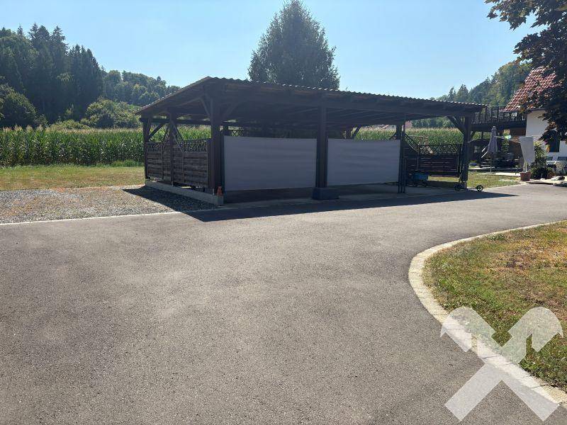 Geräumiger Carport bietet geschützten Parkplatz für mehrere Fahrzeuge auf dem Grundstück.