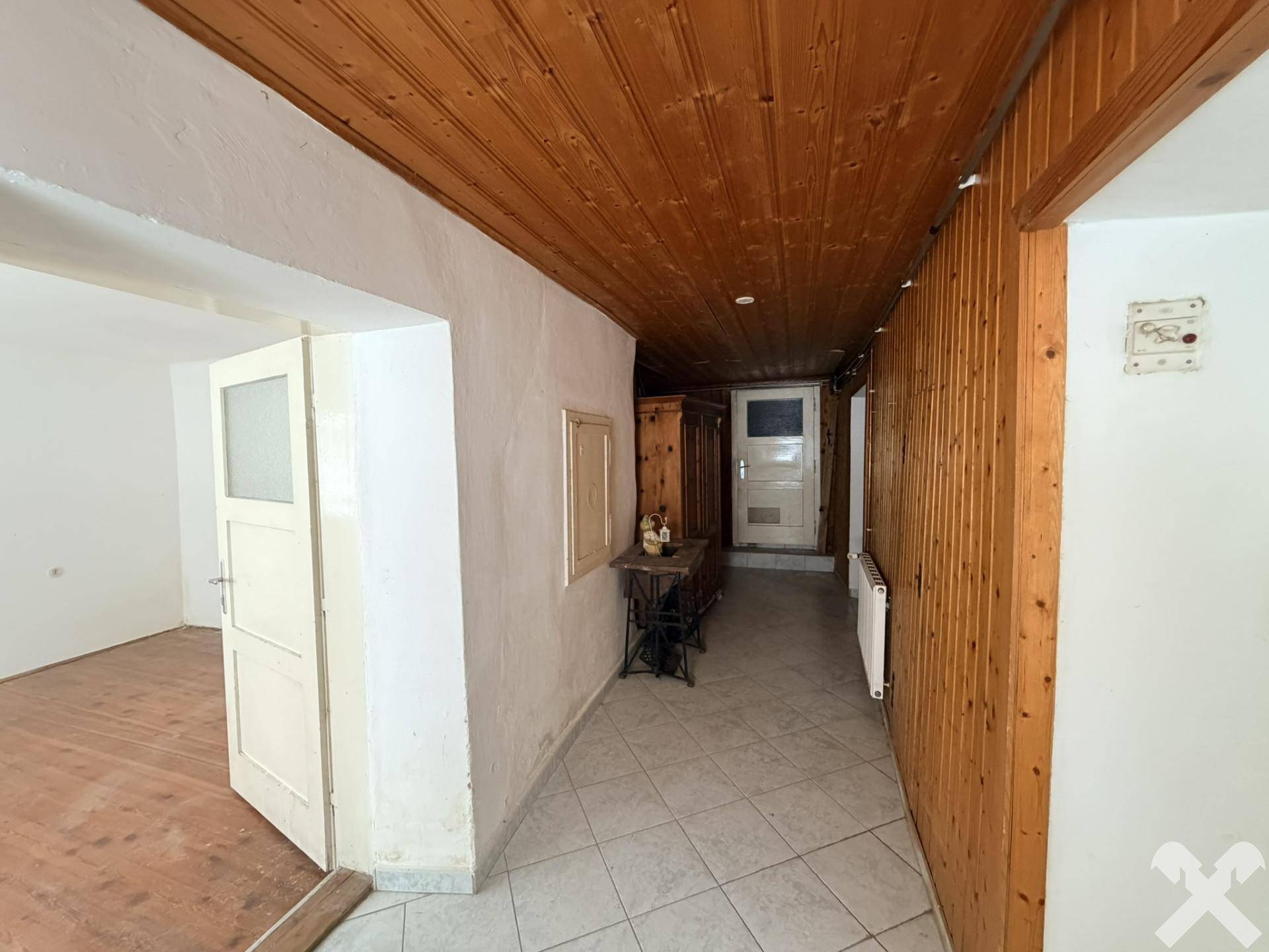Flur mit Fliesenboden, holzvertäfelten Wänden und Decke im traditionellen Stil.