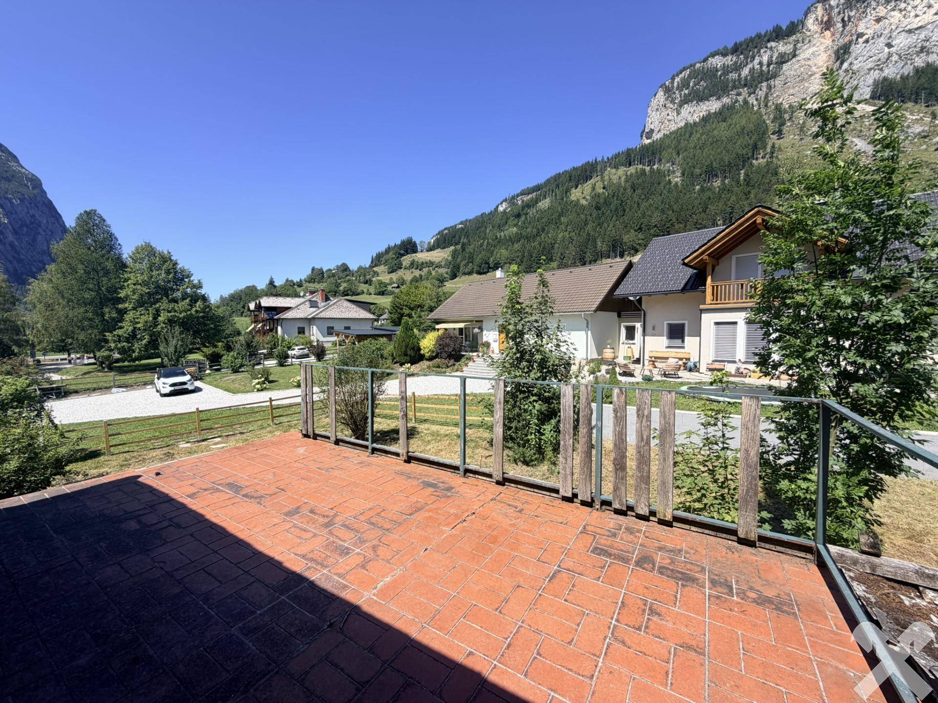 Große Terrasse mit Ziegelboden und weitem Blick auf die Berge und die Nachbarschaft.