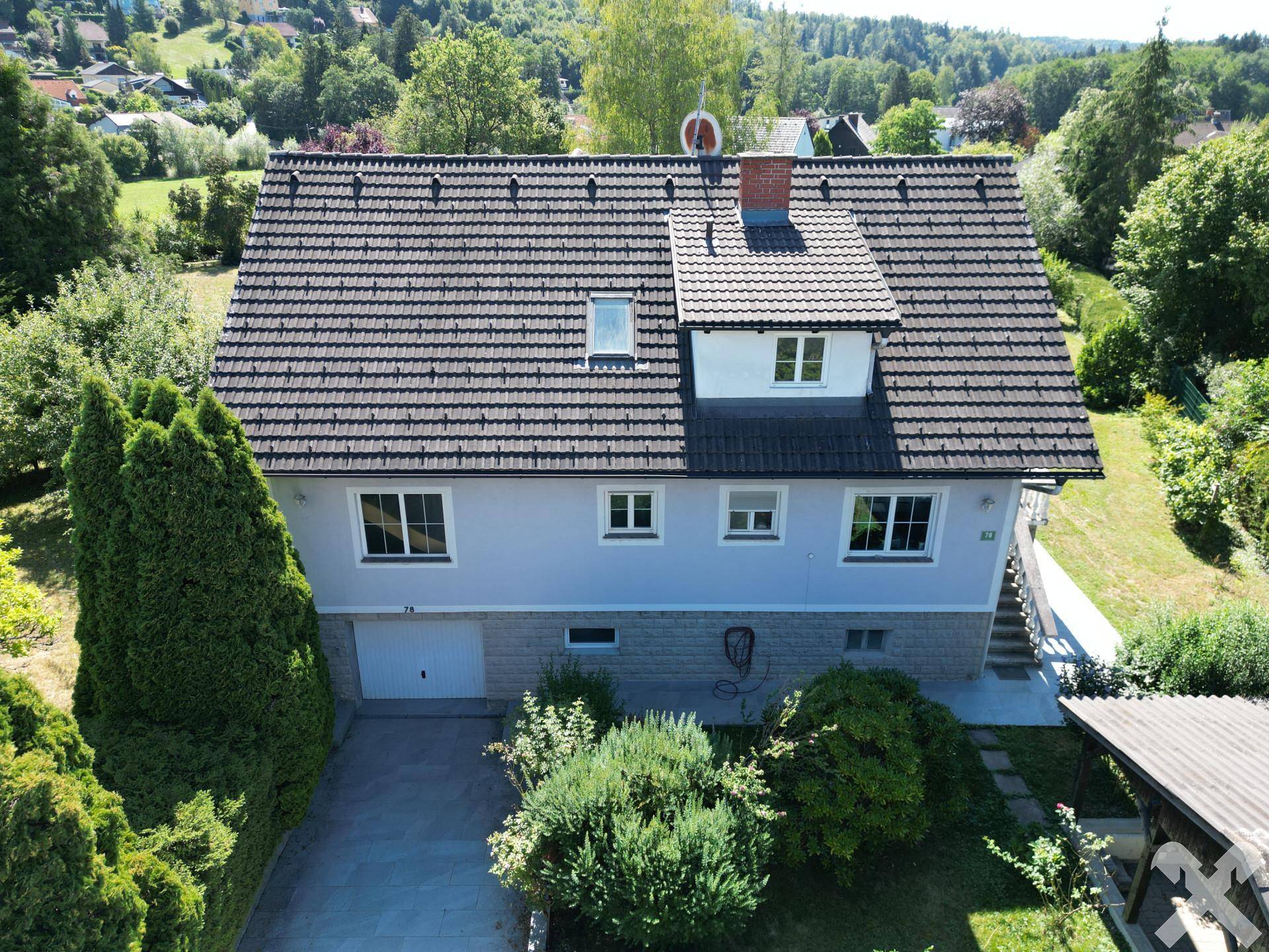 Rückansicht des Hauses mit Garage und gepflegtem Garten in sonniger Lage.