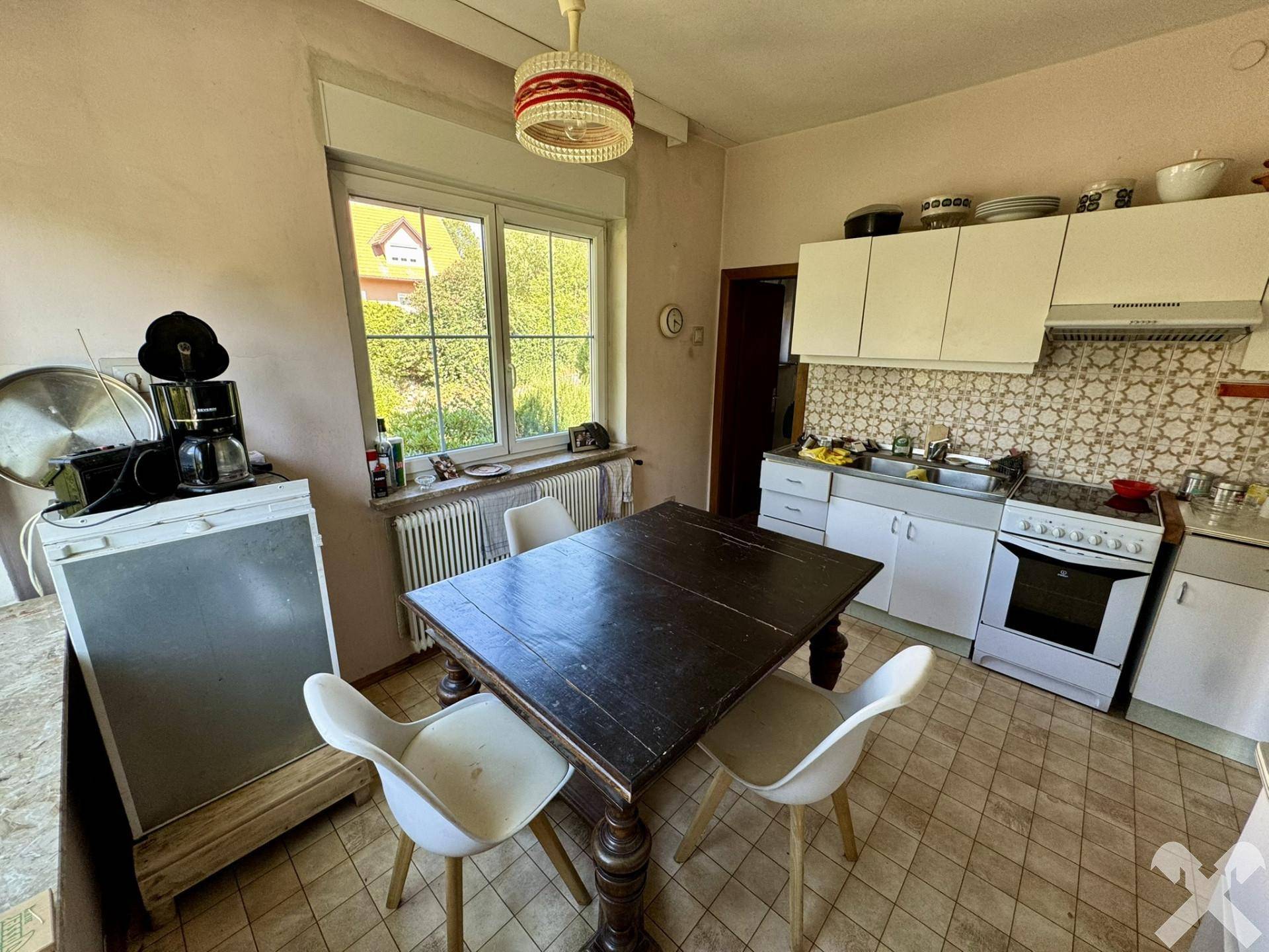 Funktionale Küche mit Essbereich, Fenster und Blick in den Garten.