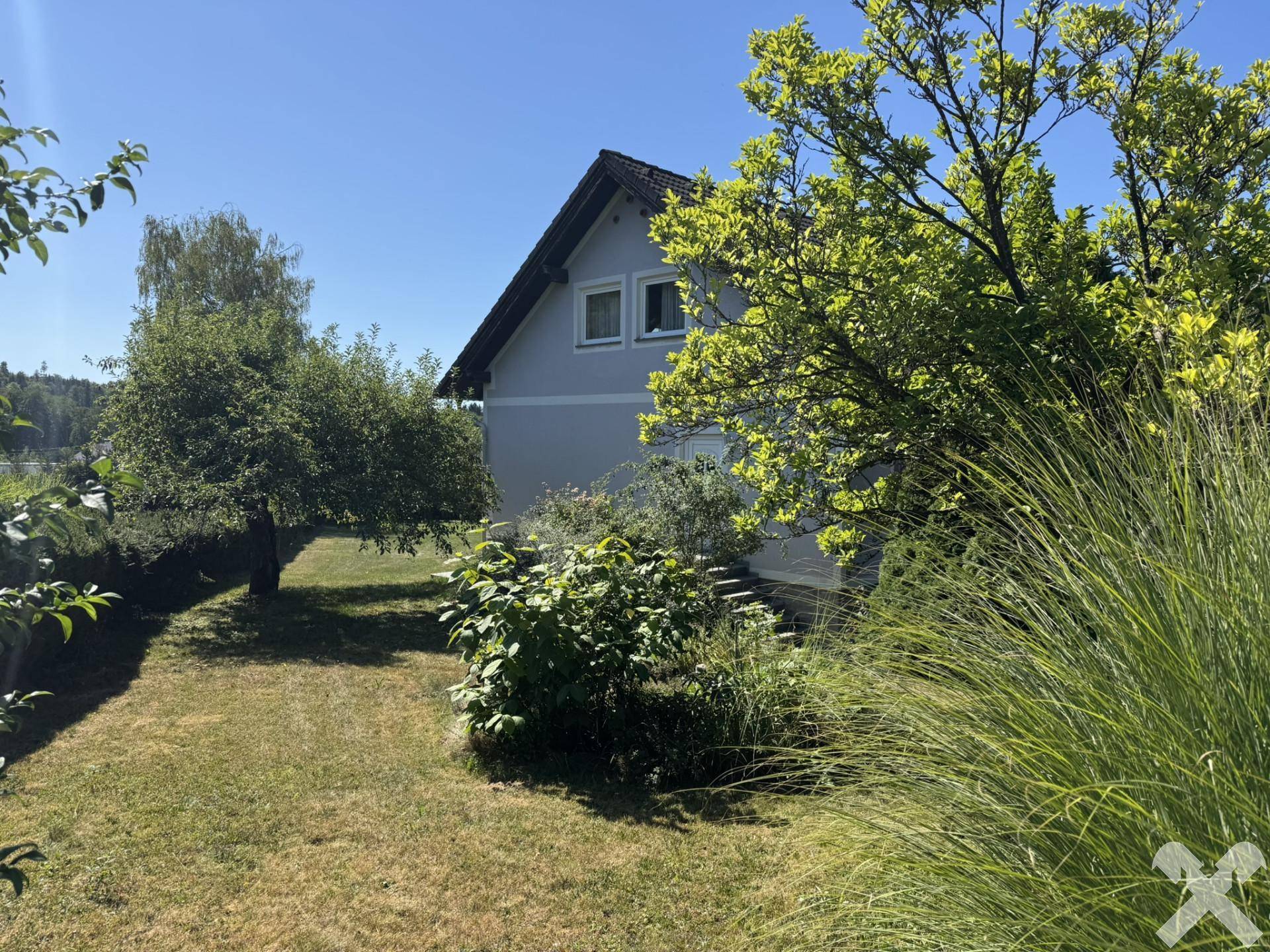 Großer, gepflegter Gartenbereich mit Rasenfläche und Bäumen, ideal zum Entspannen.