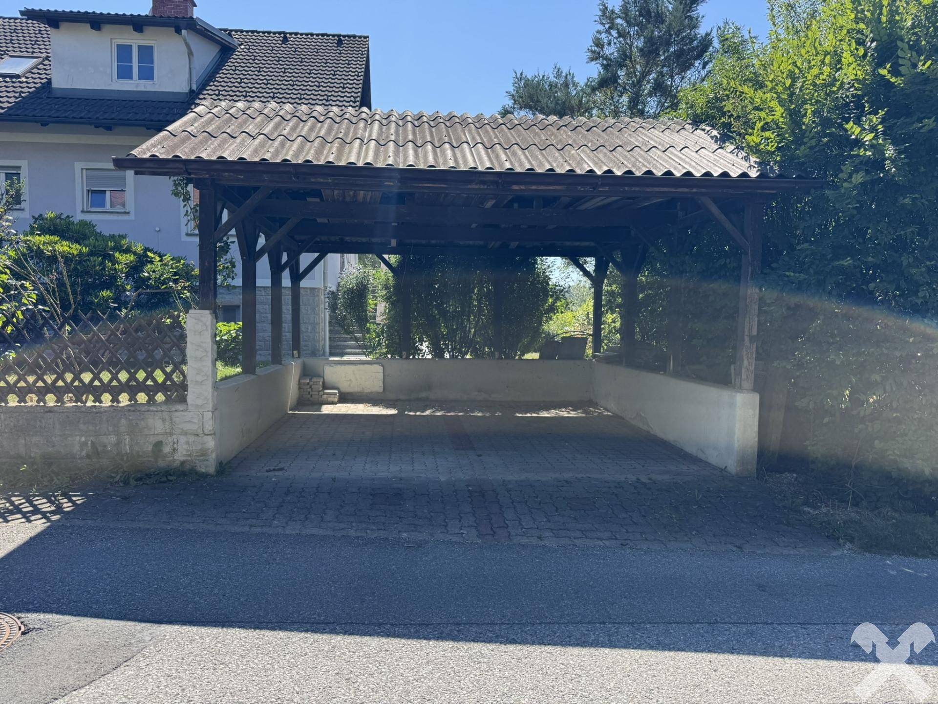 Überdachter Carport-Bereich mit Platz für mehrere Fahrzeuge, gut zugänglich.