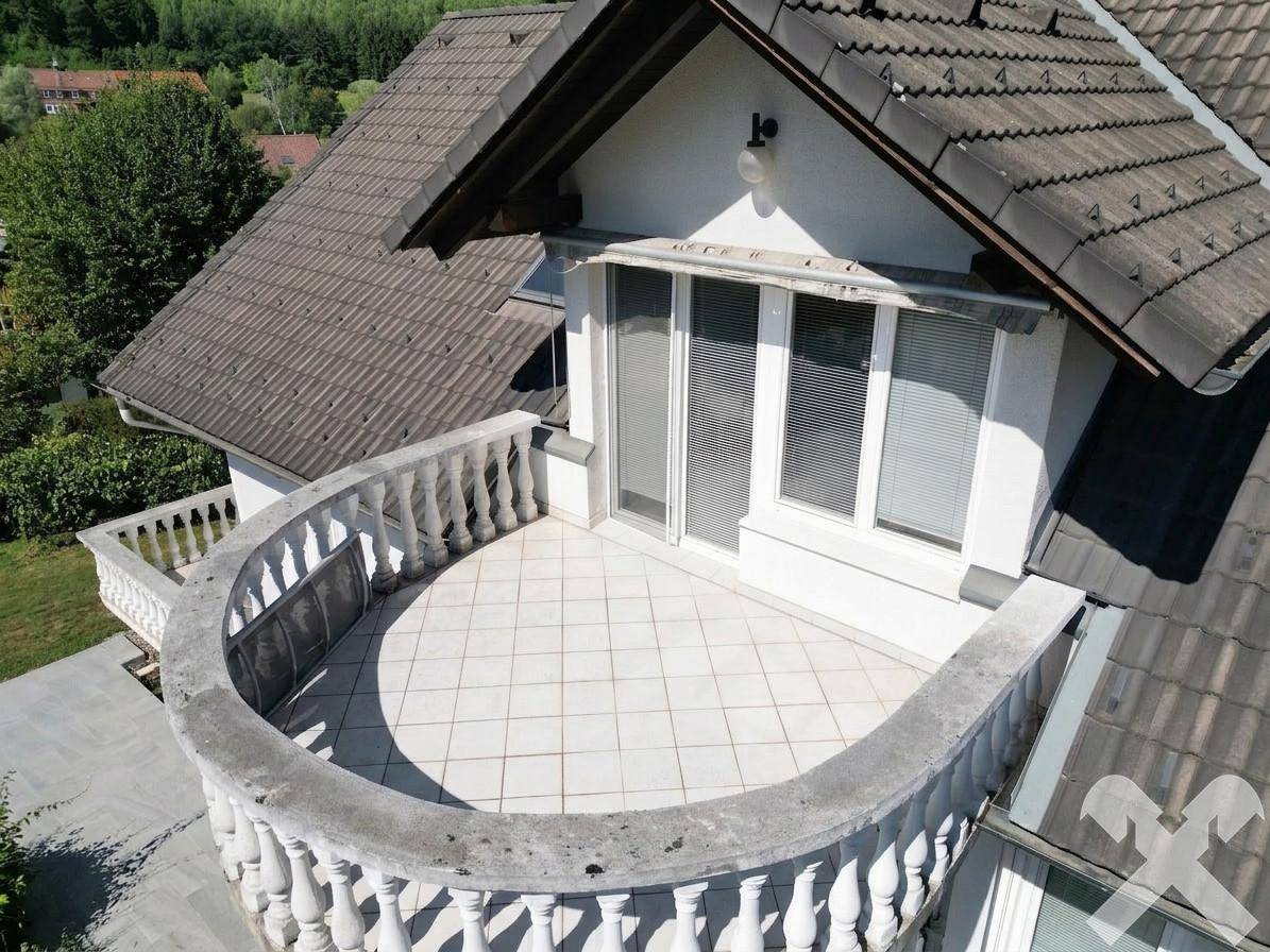 Großer runder Balkon mit Fliesenboden und Balustrade, ideal für Entspannung.