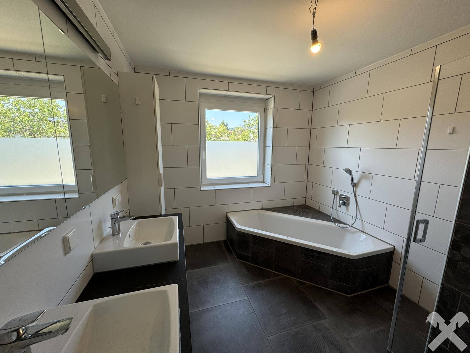 Modernes Badezimmer mit zwei Waschbecken, Badewanne und Duschkabine.