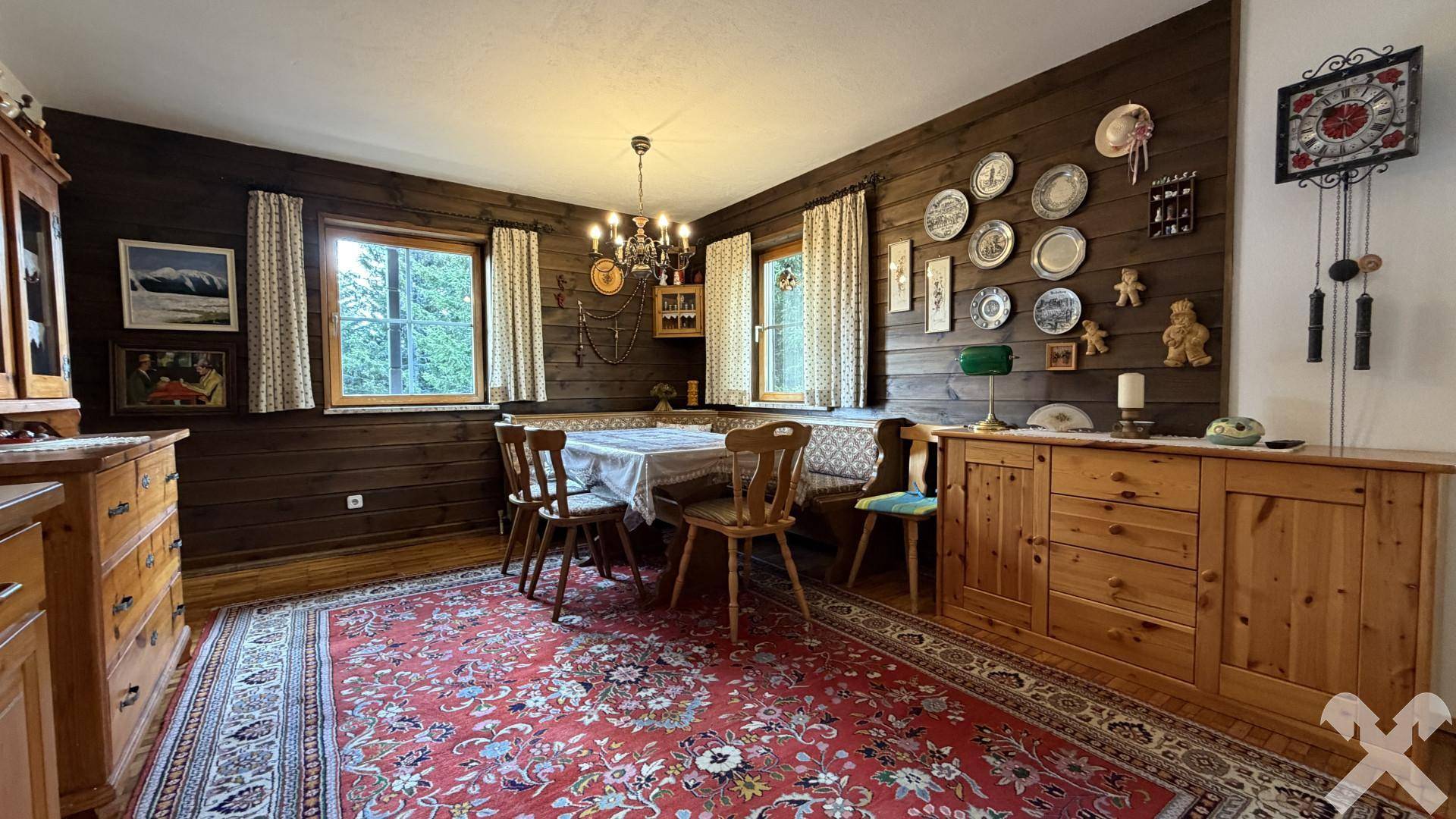 Gemütlicher Essbereich mit holzvertäfelten Wänden, traditionellen Möbeln und Teppichboden.