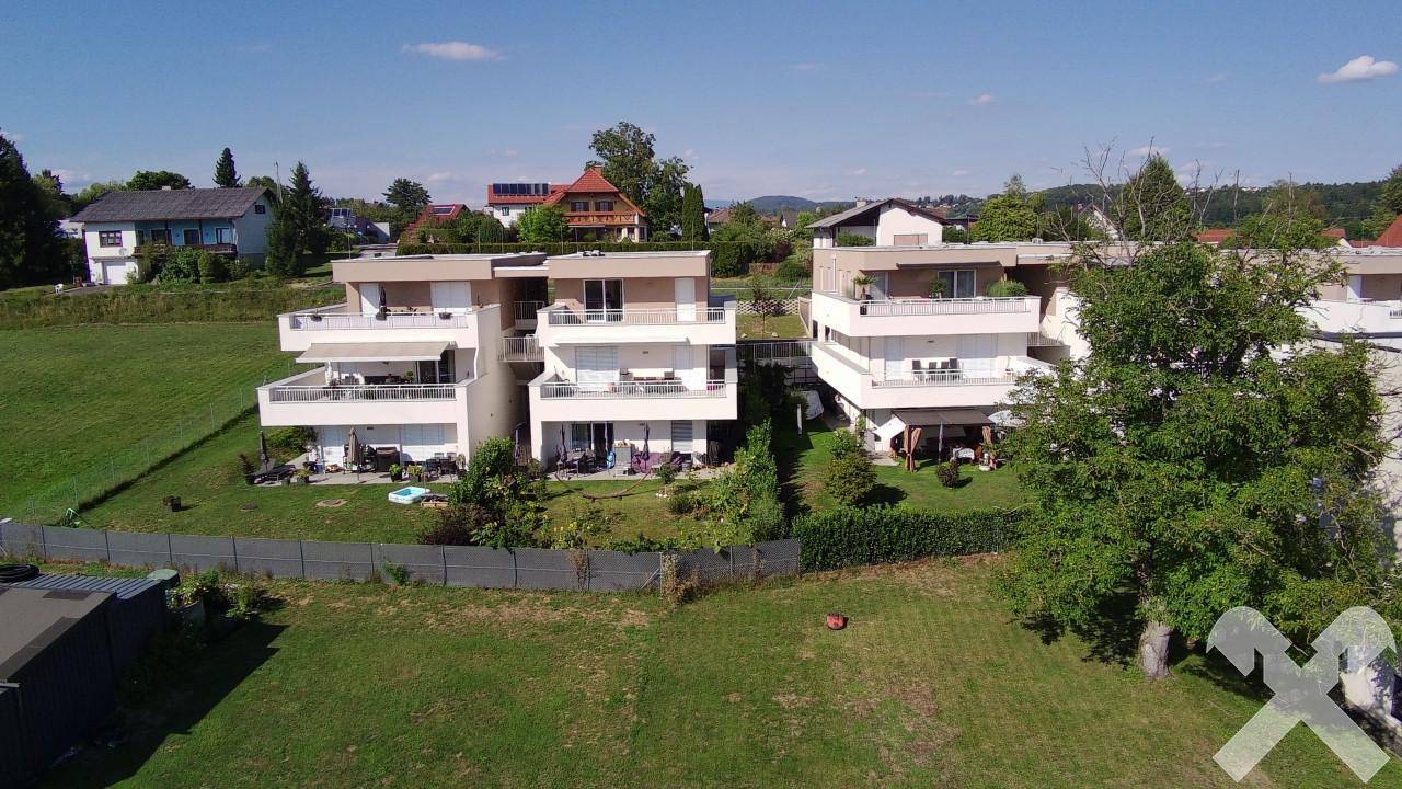 Luftaufnahme einer modernen Wohnsiedlung mit hellen Fassaden und weitläufigen Grünflächen.