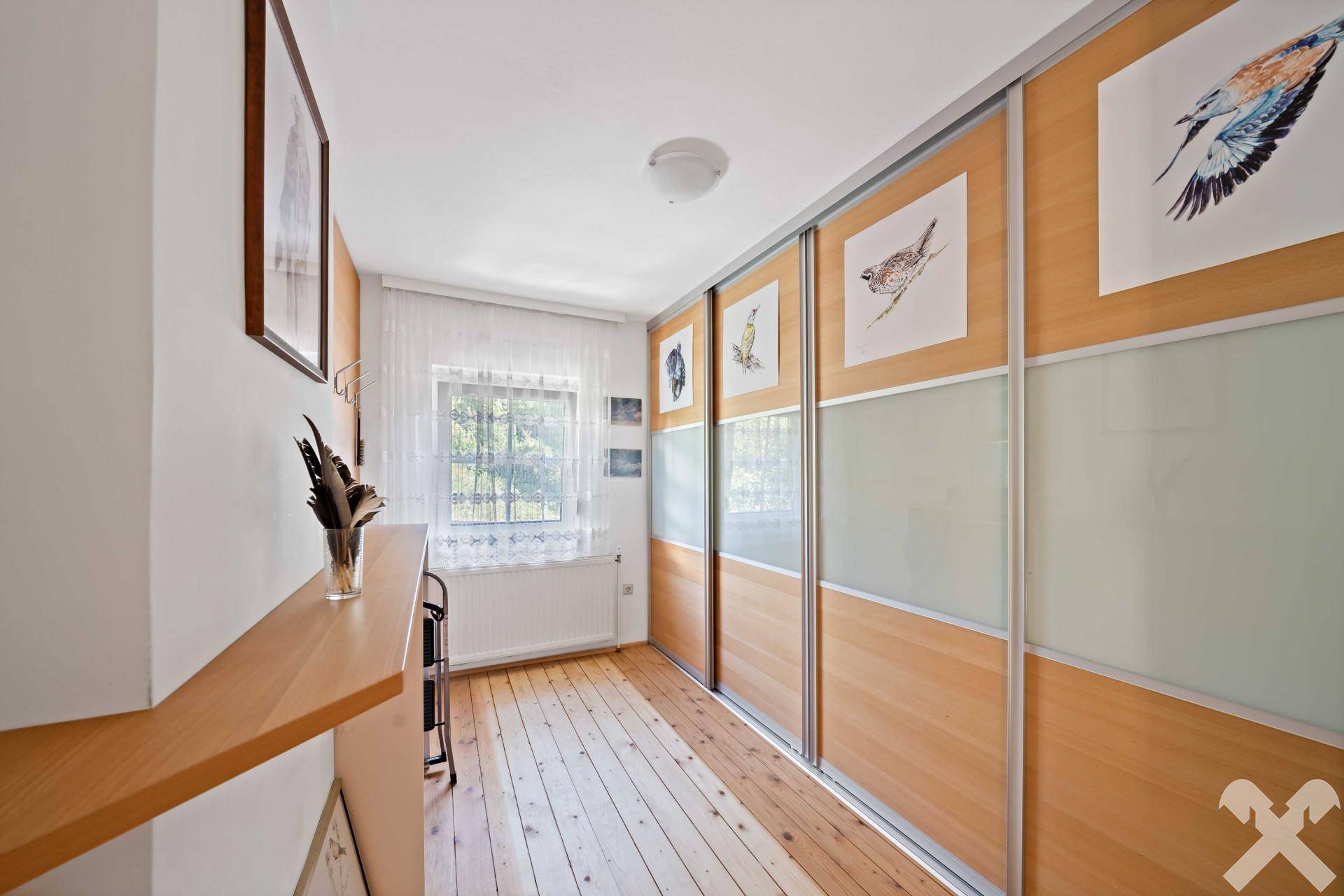 Schlafzimmer mit praktischen Einbauschränken und einem Fenster für natürliche Belichtung.