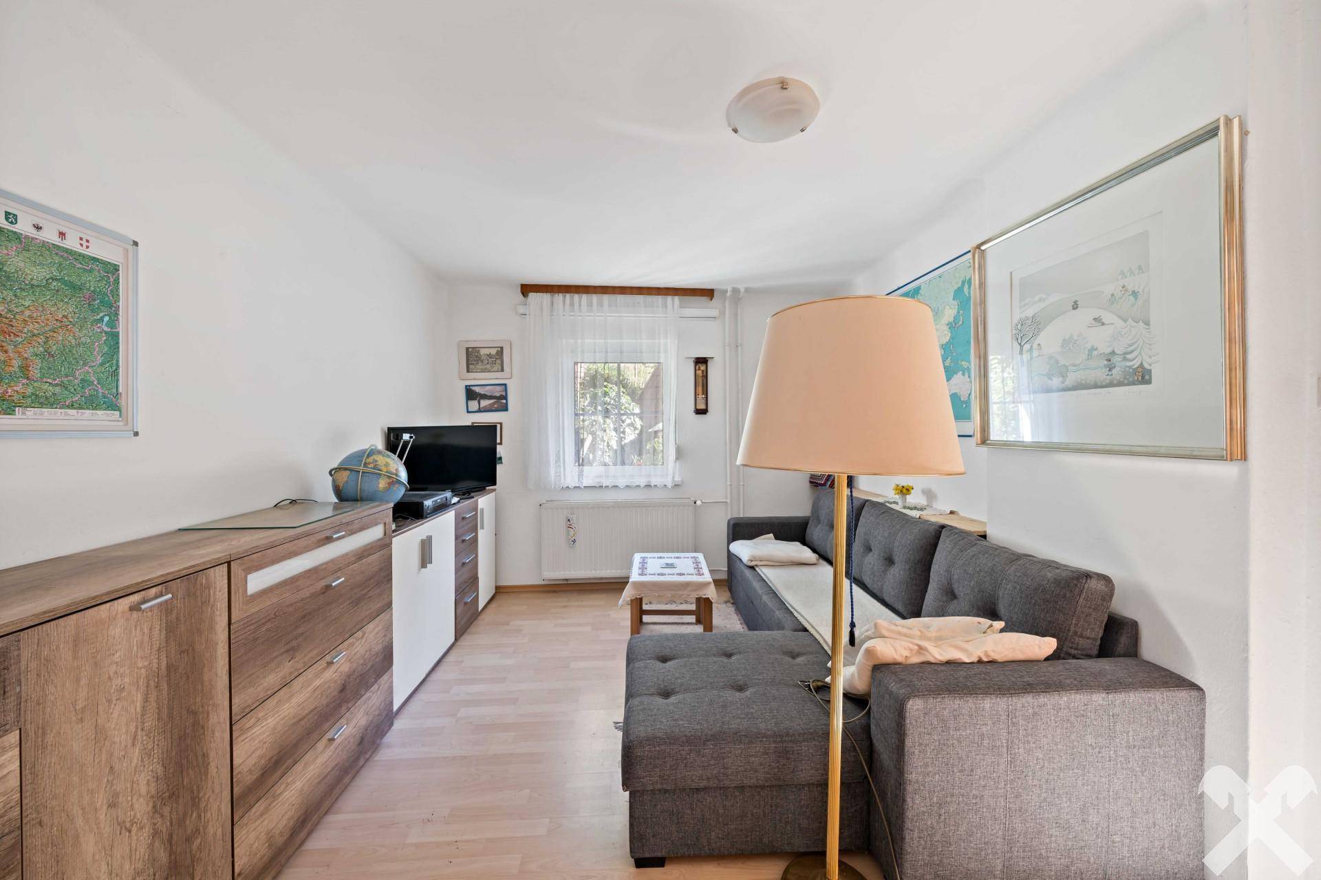 Helles Wohnzimmer mit bequemer Couch, TV-Möbeln und hellem Holzboden.
