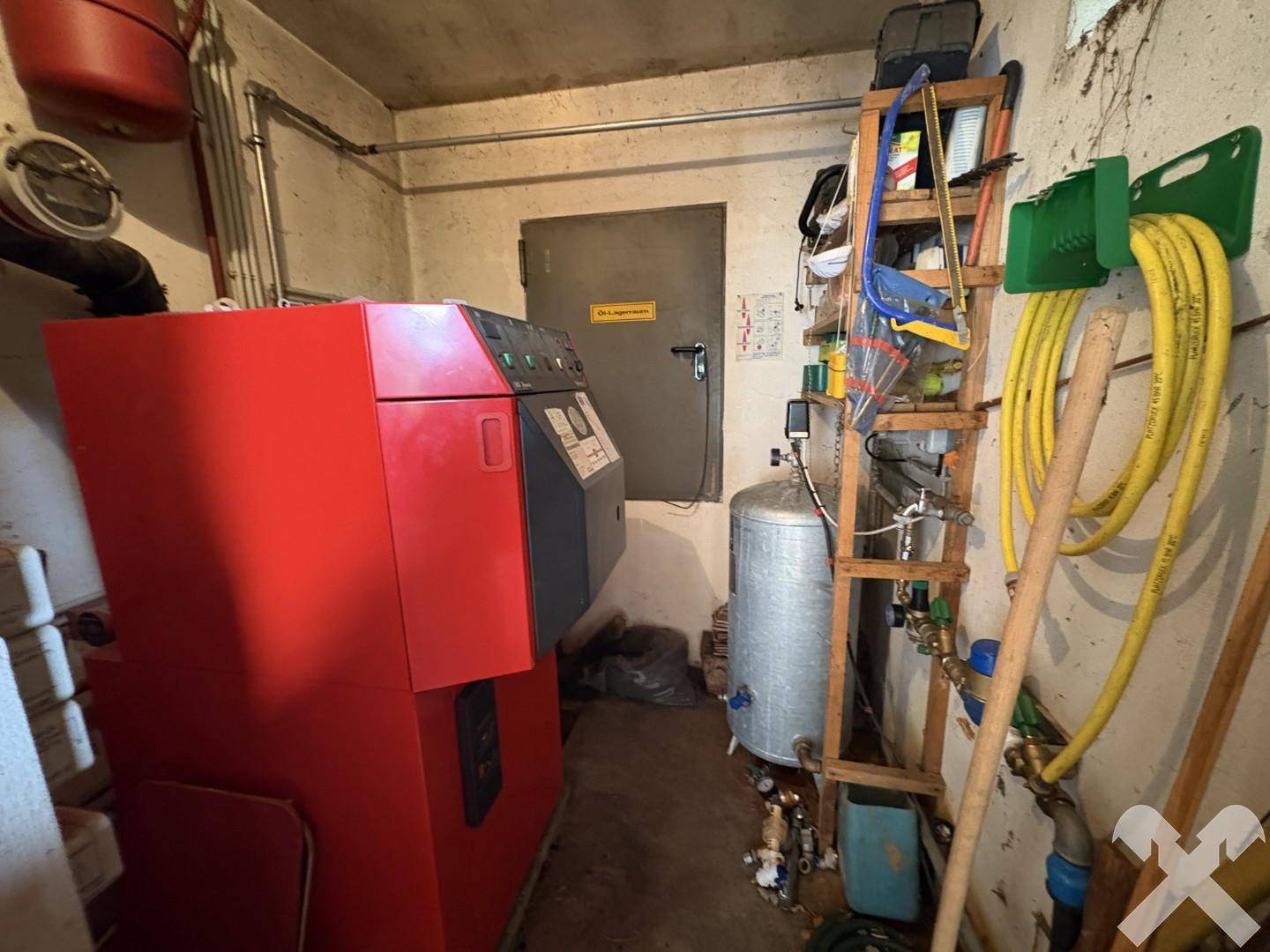 Heizungsraum mit großem Heizkessel und verschiedenen Installationen in funktionalem Zustand.