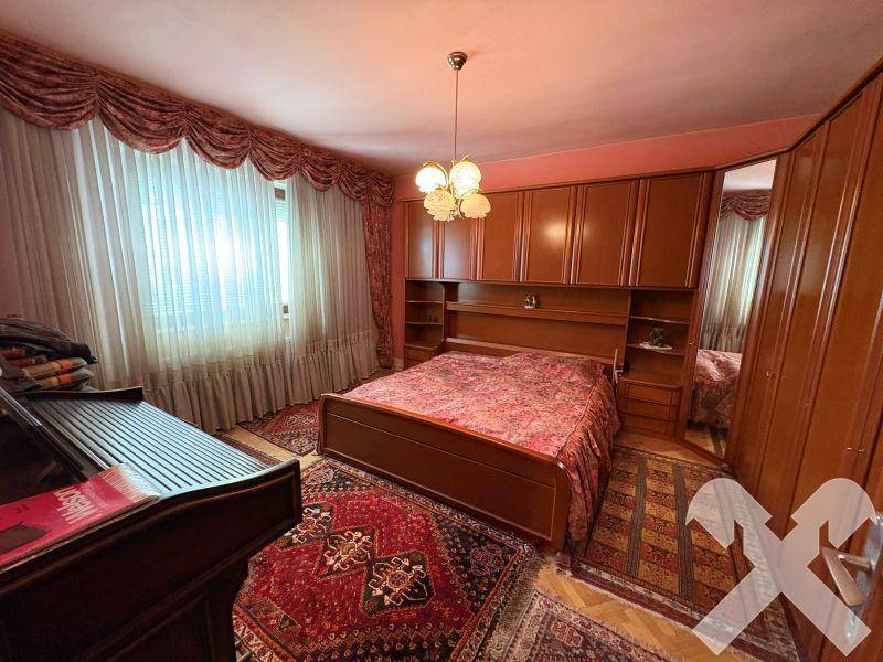 Schlafzimmer mit großem Doppelbett, Einbauschränken und traditionellem Teppichboden.