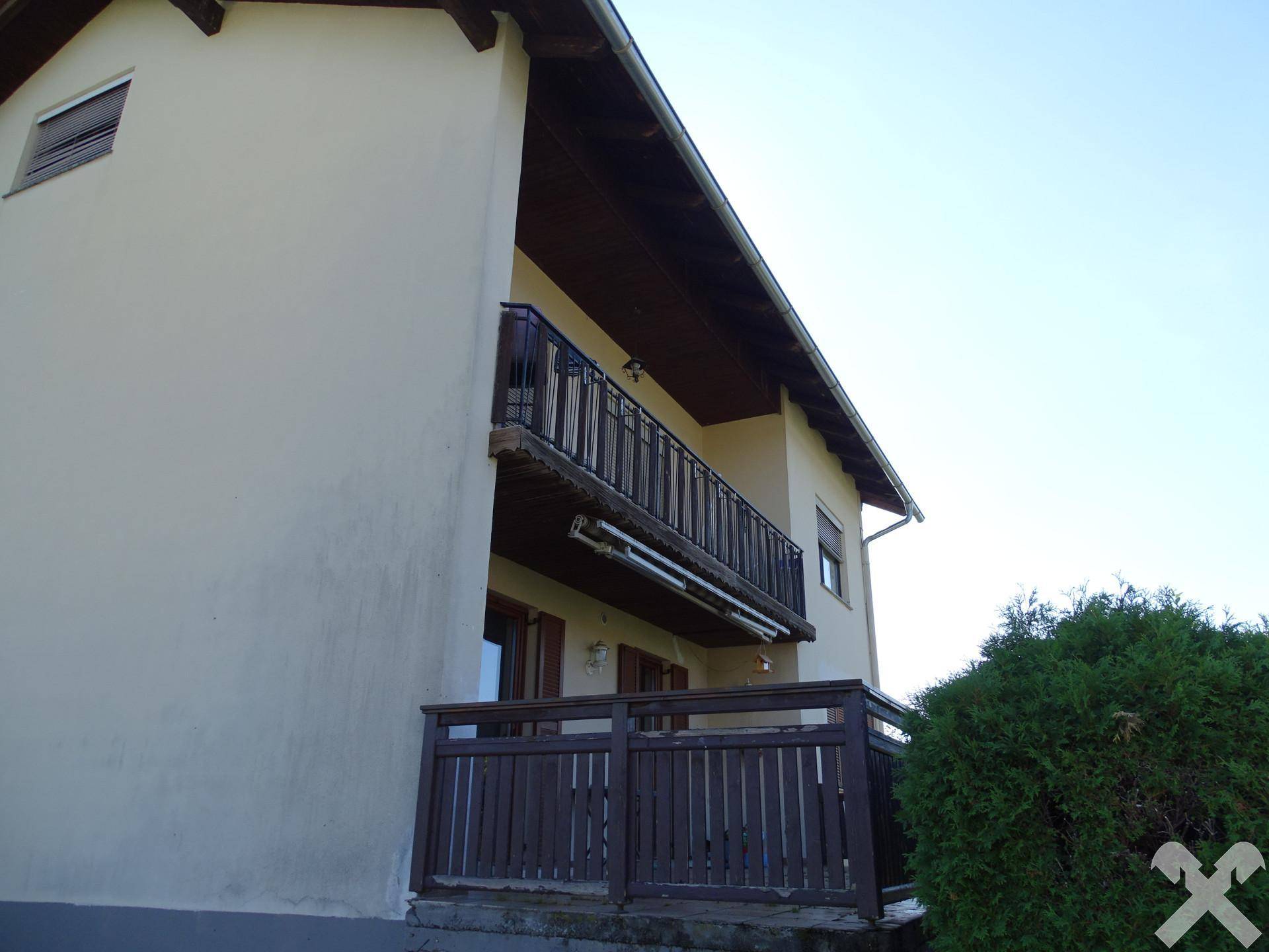 Detailansicht der Balkone mit Holzgeländer und traditioneller Architektur des Hauses.