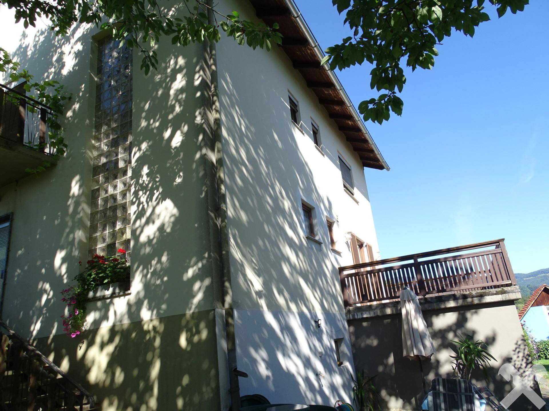 Seitliche Ansicht des Hauses mit Terrasse, Glasbausteinen und viel natürlichem Licht.