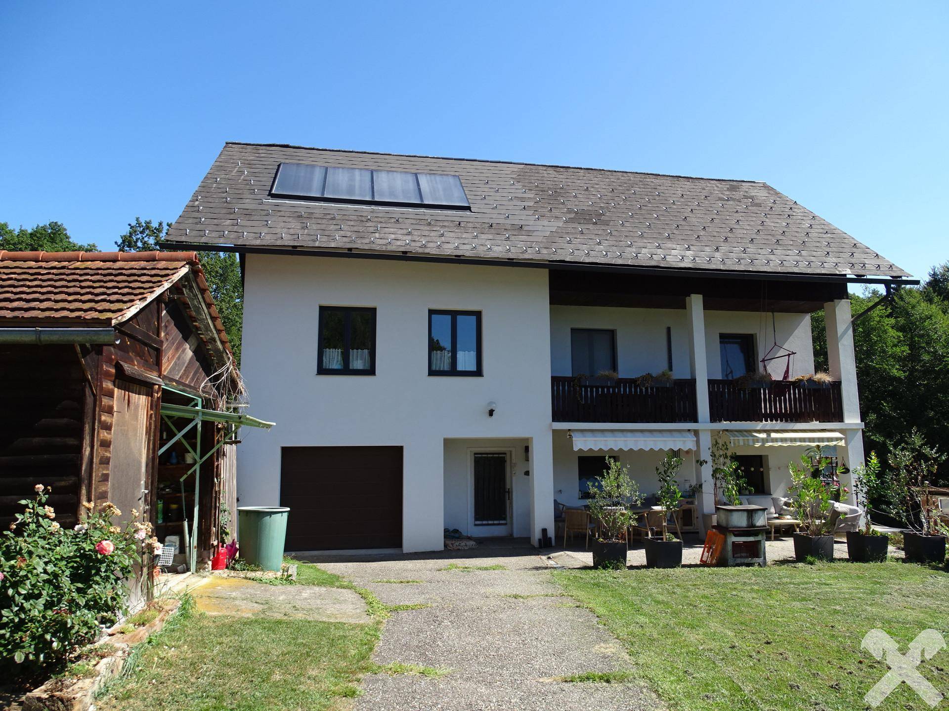 Vorderansicht des Wohnhauses mit Balkon, Terrasse und Solaranlage auf dem Satteldach.