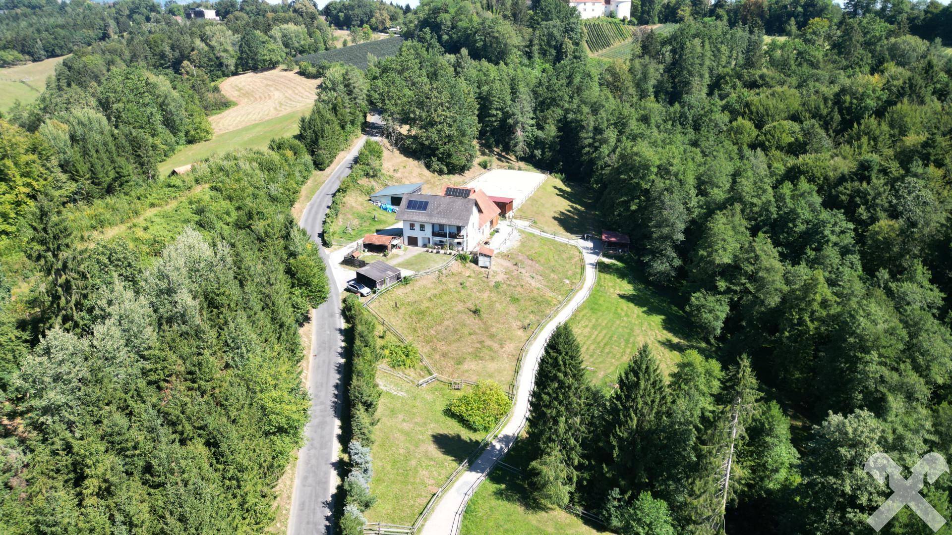 Panoramablick aus der Luft auf das ländliche Anwesen, umgeben von Wäldern und grünen Hügeln.