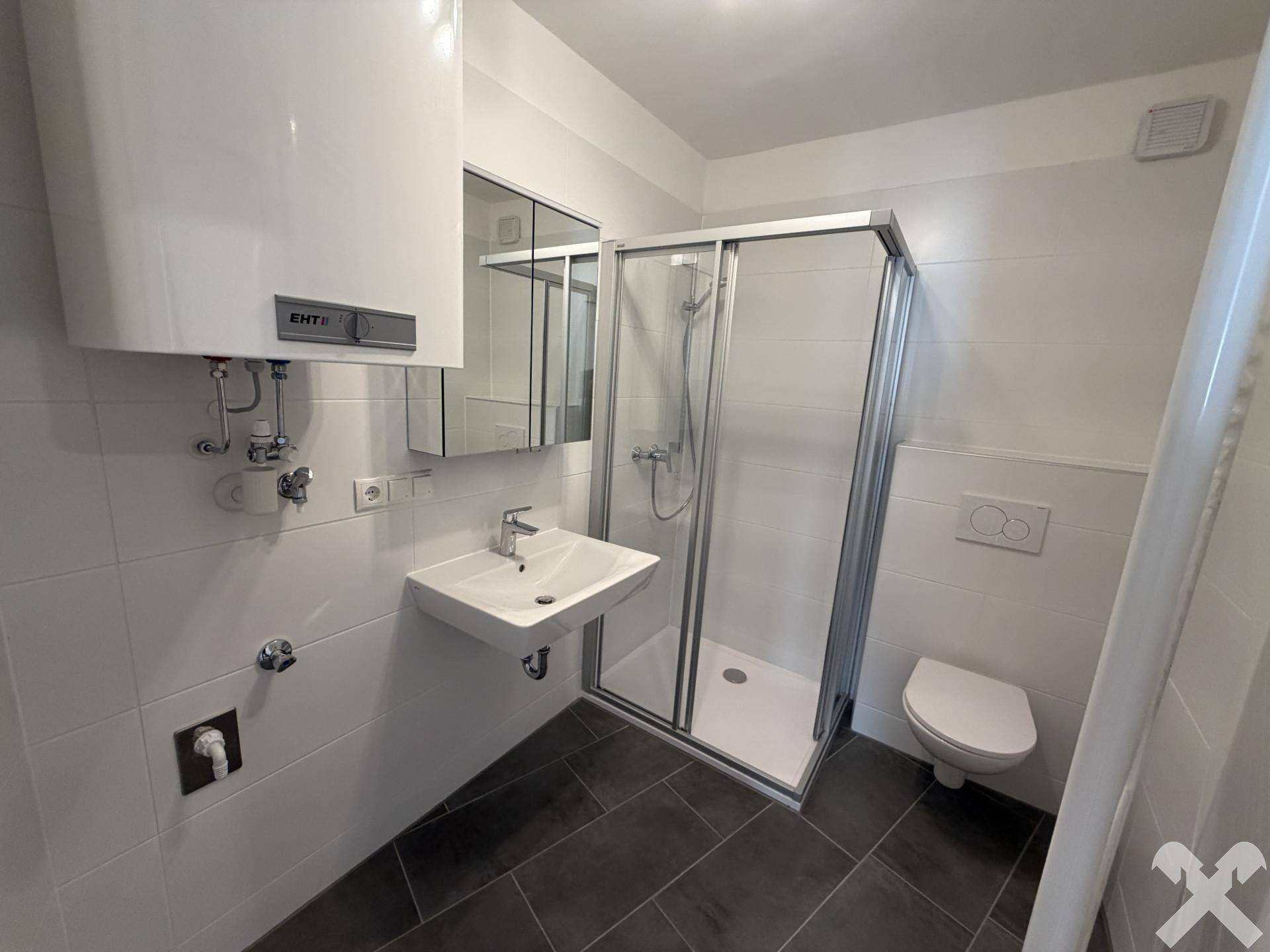 Modernes Badezimmer mit Duschkabine, Waschbecken, WC und Wandfliesen in Weiß.