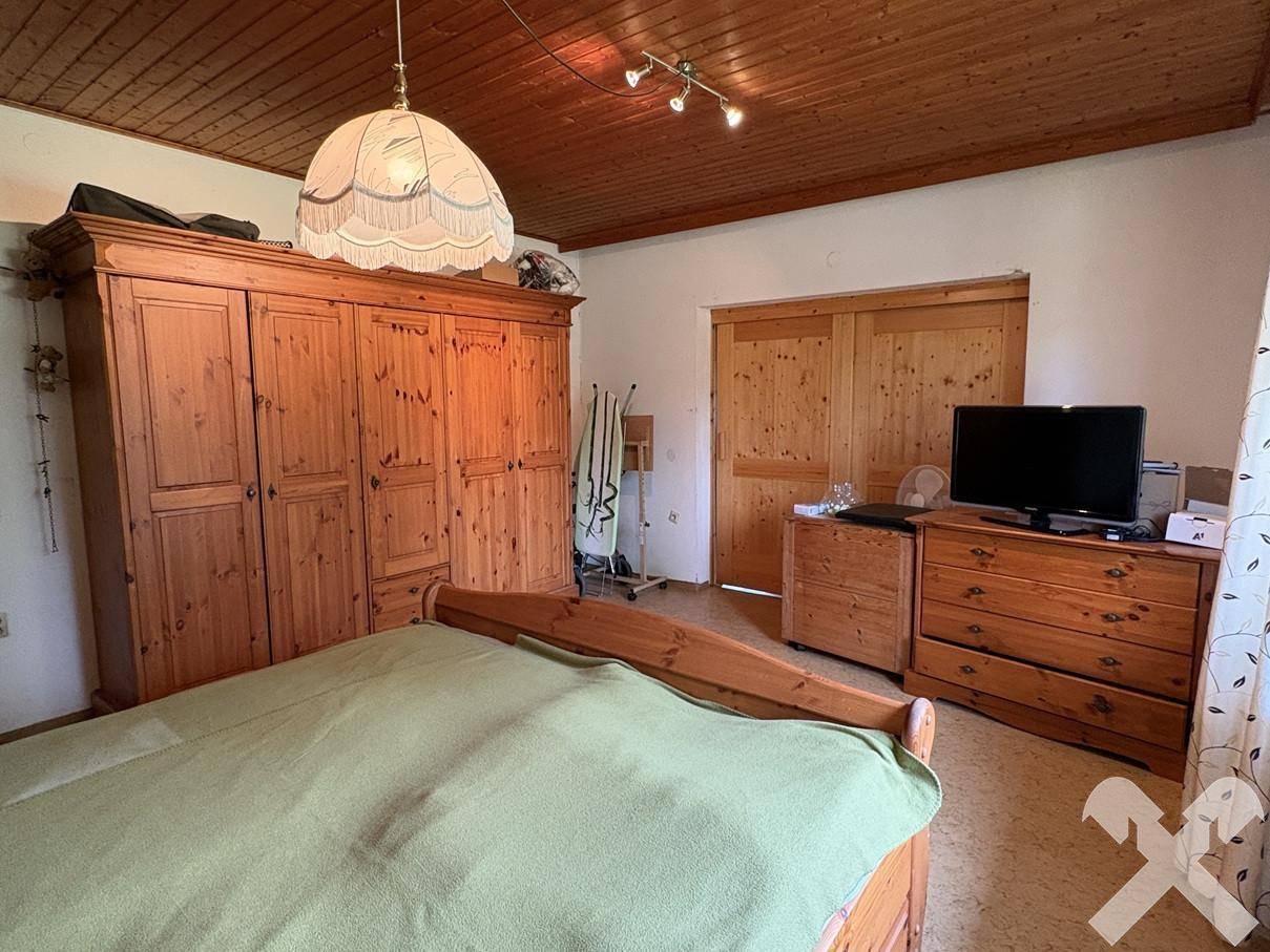 Geräumiges Schlafzimmer mit großem Holzschrank und Holztüren.