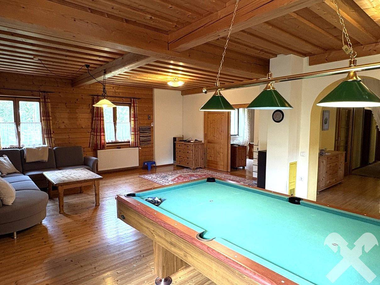 Weitläufiges Wohnzimmer mit Billardtisch und Blick in den Essbereich.
