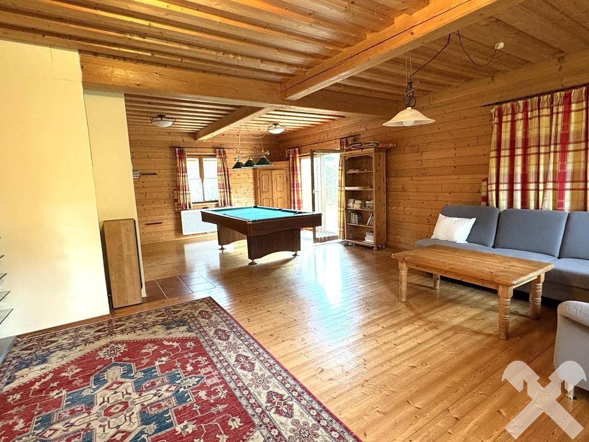 Gemütliches Wohnzimmer mit Sofa, Couchtisch und Billardtisch.