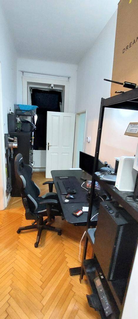 Arbeitszimmer mit Schreibtisch, Bürostuhl und Holzparkettboden.