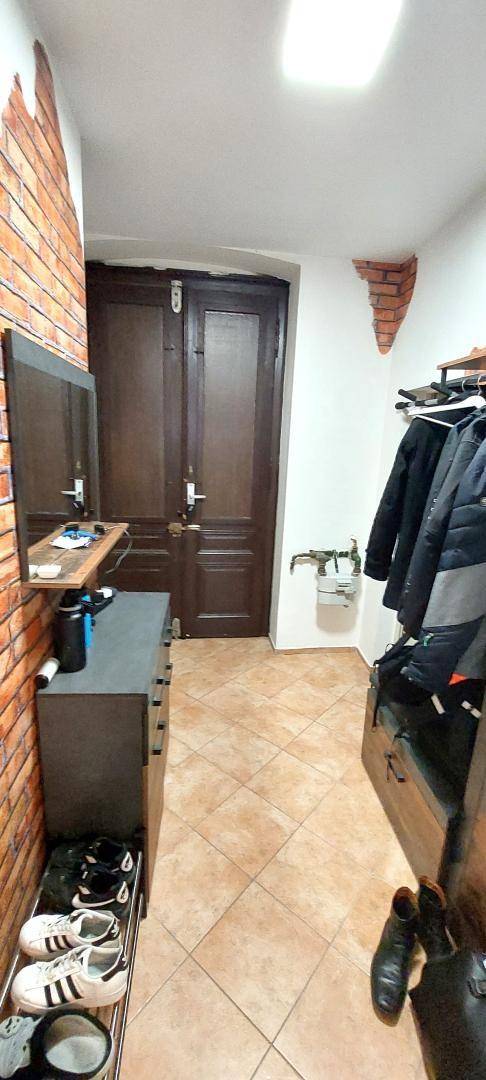 Eingangsbereich mit Ziegelwandakzenten, Fliesenboden und Garderobe.