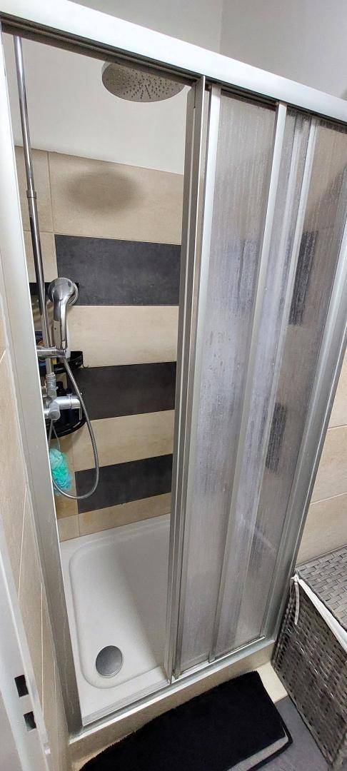 Modernes Badezimmer mit begehbarer Dusche und Regenduschkopf.