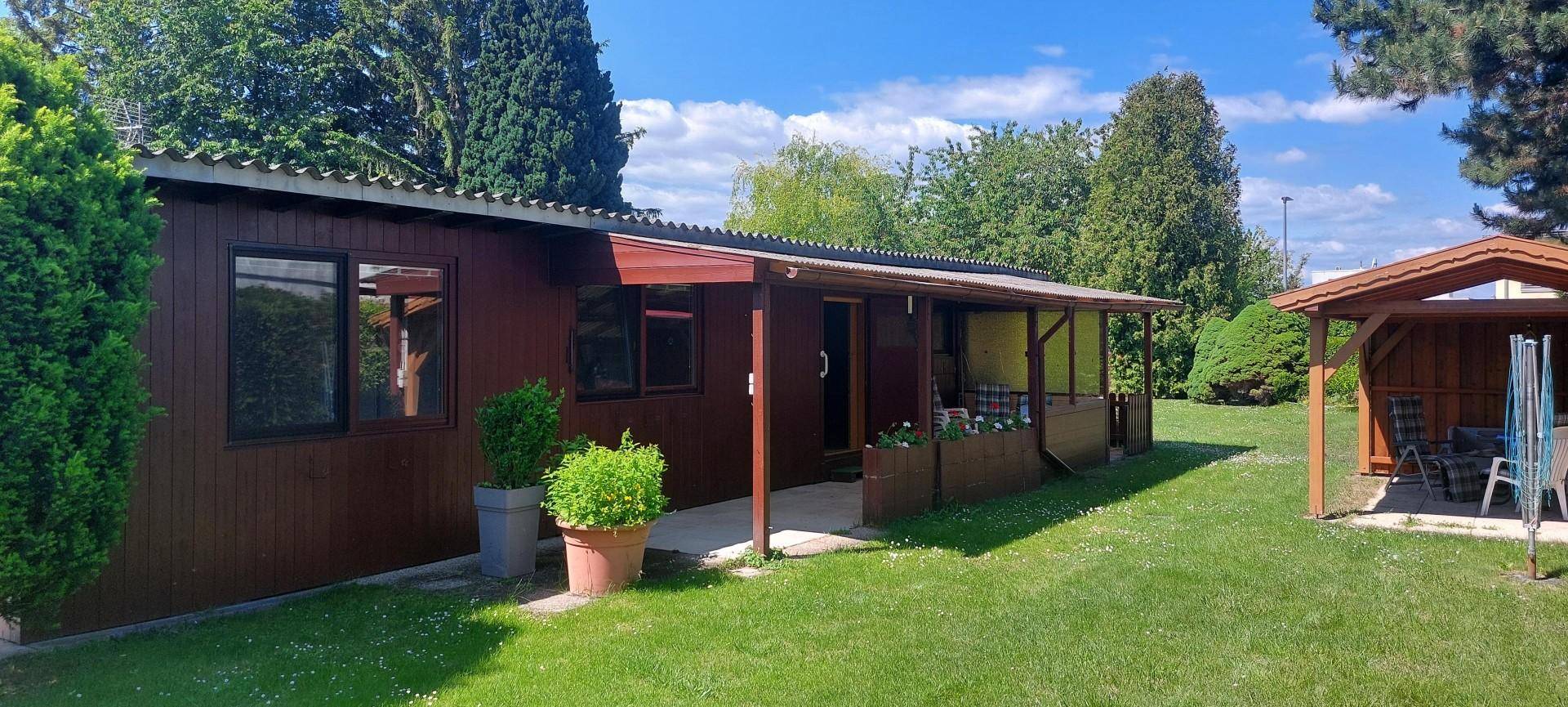 Holzhaus mit überdachter Terrasse, die zum Entspannen im Freien einlädt.