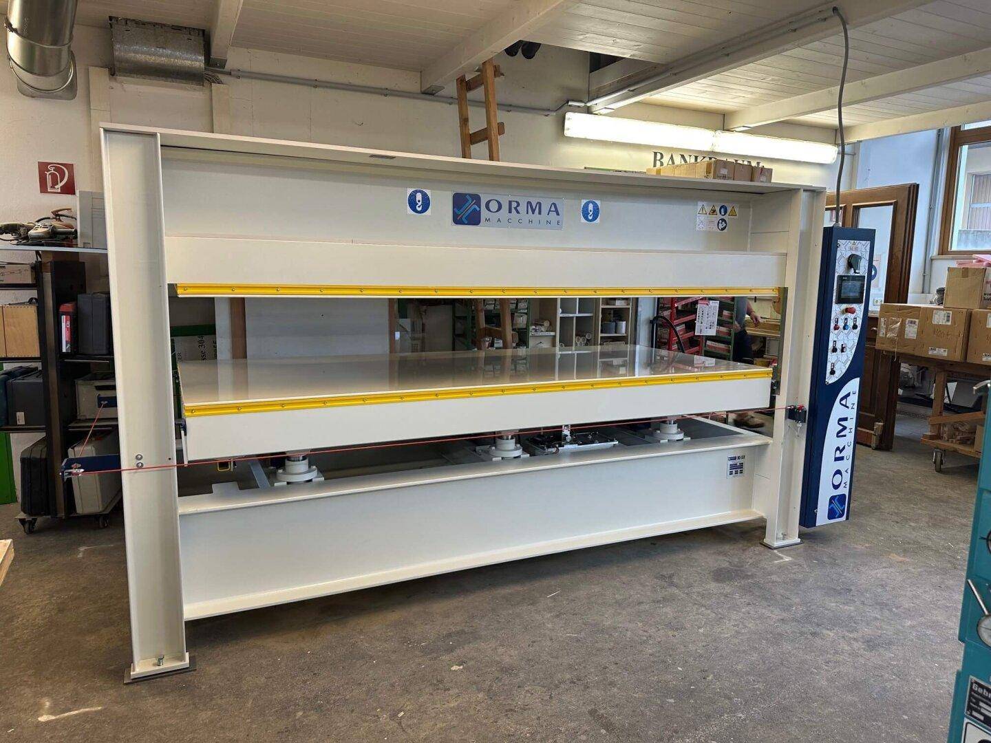 Moderne Holzpresse der Marke Orma Macchine in einer gut beleuchteten Werkstatt.
