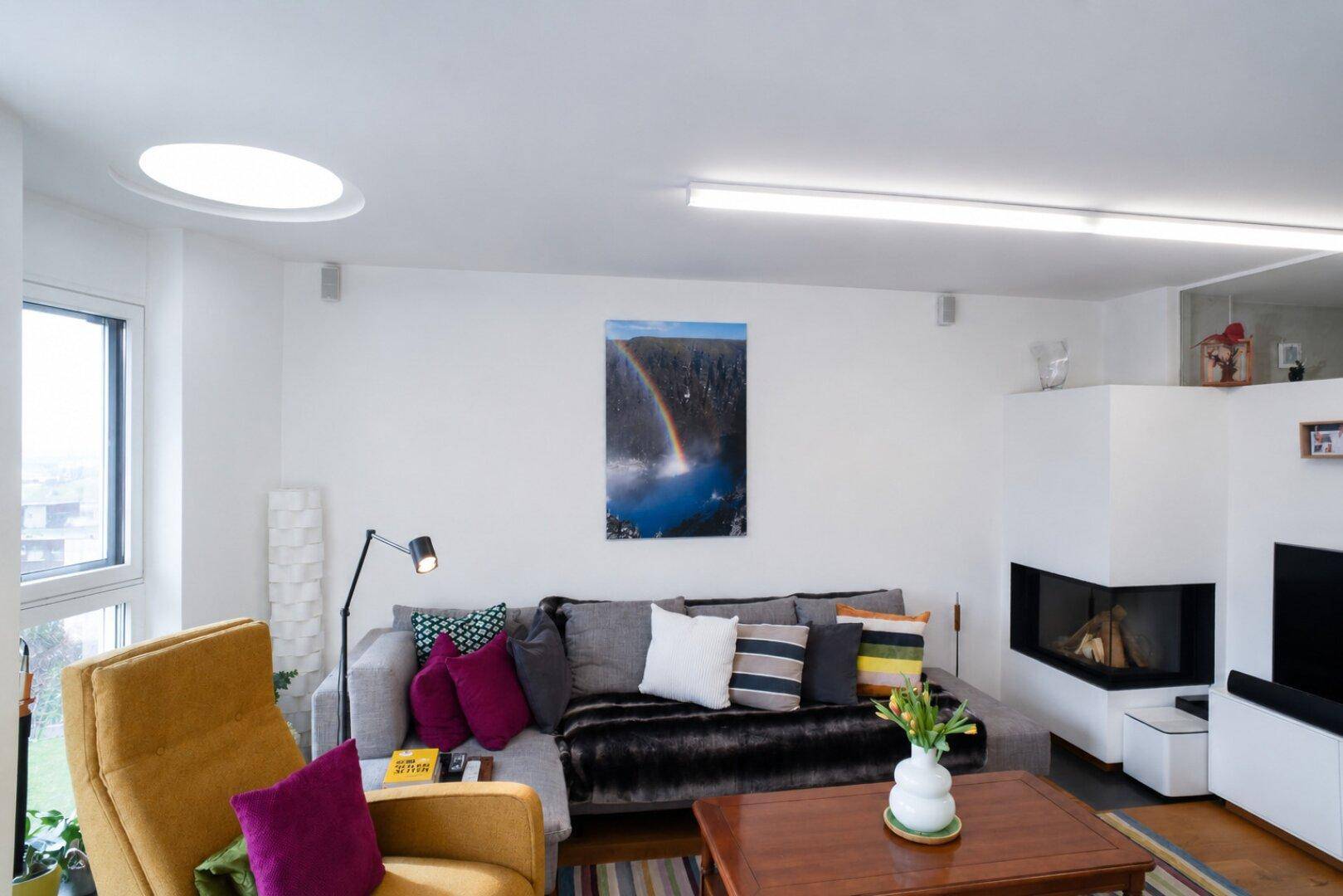 Gemütlicher Wohnbereich mit großem Sofa, modernem Kamin und farbenfrohen Kissen, lädt zum Verweilen ein.