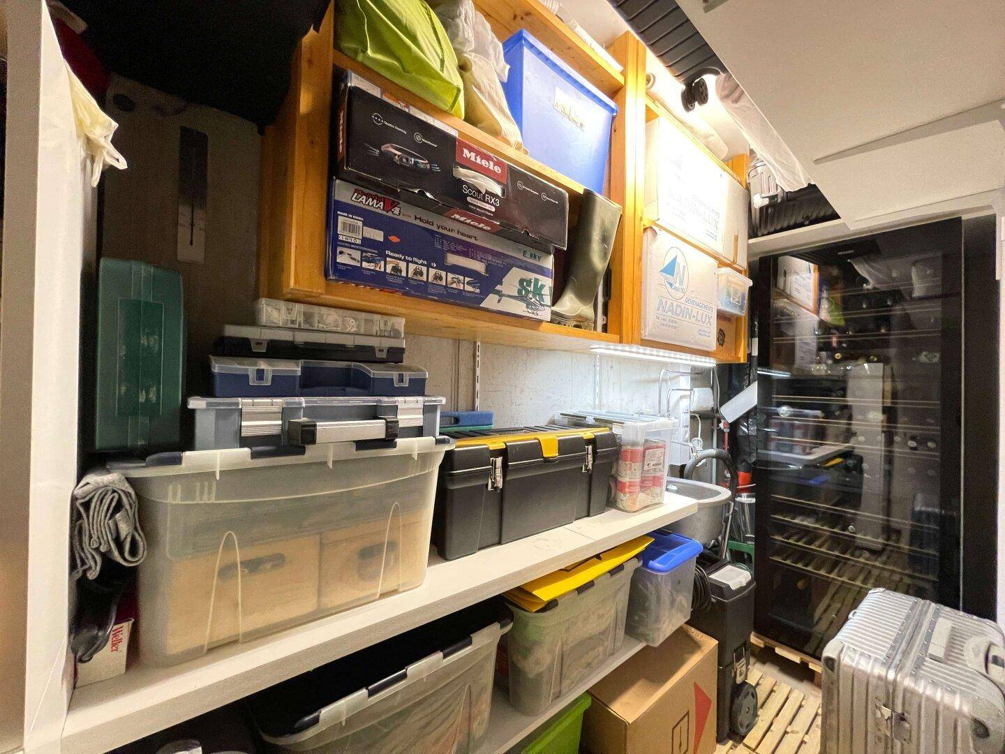 Gut organisierter Abstellraum mit Regalen, Aufbewahrungsboxen und einem Weinkühlschrank, bietet viel Platz.