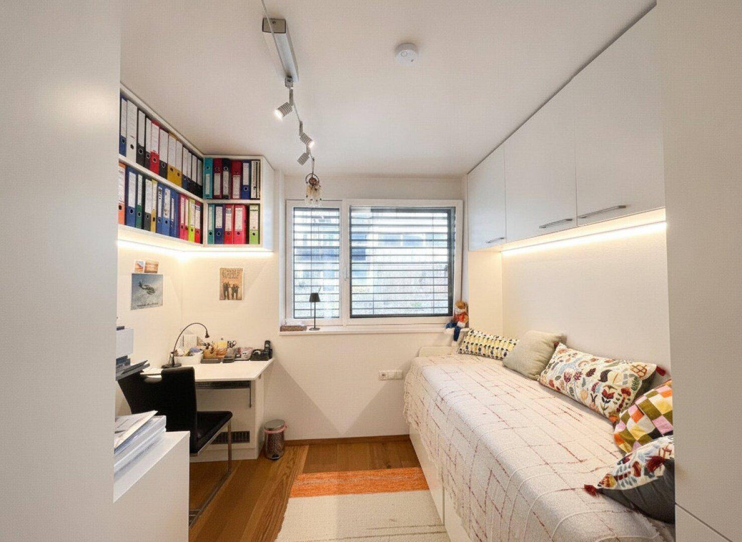 Helles Schlafzimmer oder Büro mit Einzelbett, Schreibtisch und Einbauschränken, ideal für Gäste oder Arbeit.