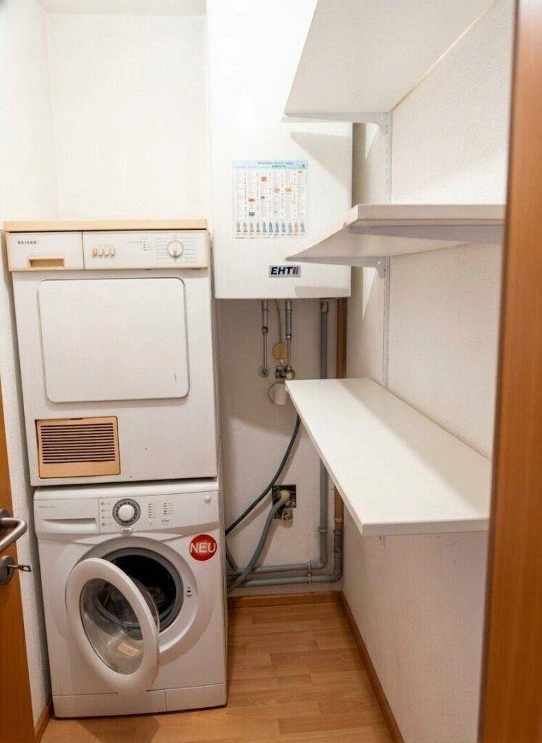 Praktischer Hauswirtschaftsraum mit Waschmaschine, Trockner und Regalen für Stauraum.