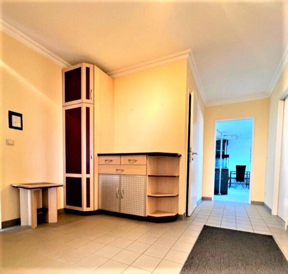 Heller Flur mit praktischem Eckschrank und Blick in einen angrenzenden Raum.