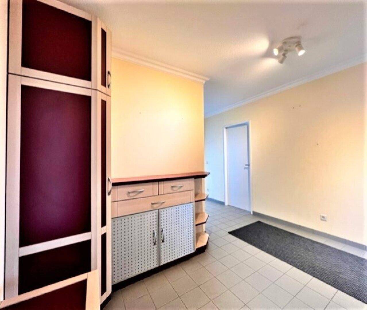 Geräumiger Flur mit Einbauschrank und heller Wandfarbe, gut beleuchtet.