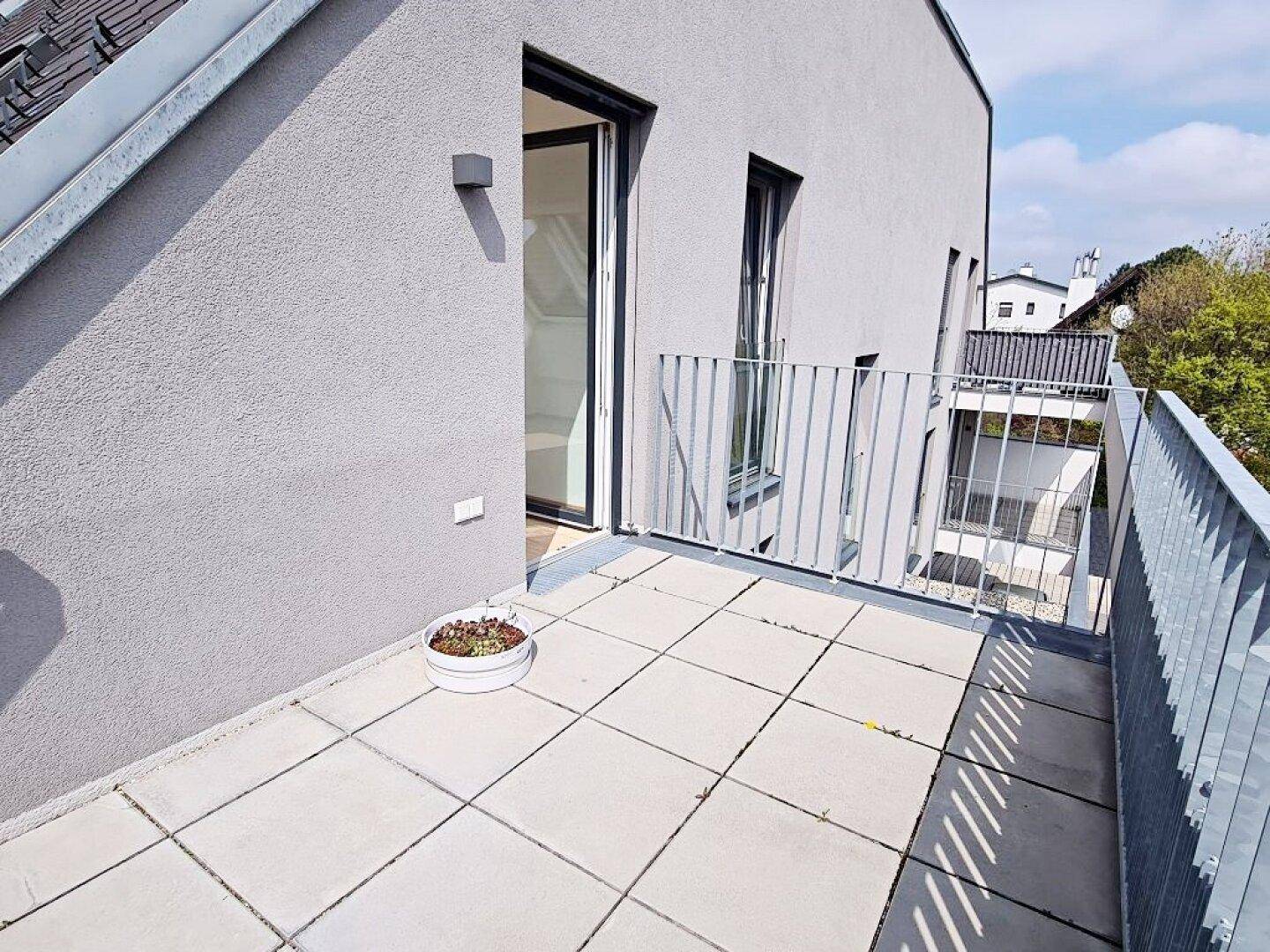 Kleiner Balkon mit Fliesenboden und Metallgeländer, ideal für eine kleine Pflanzendekoration.