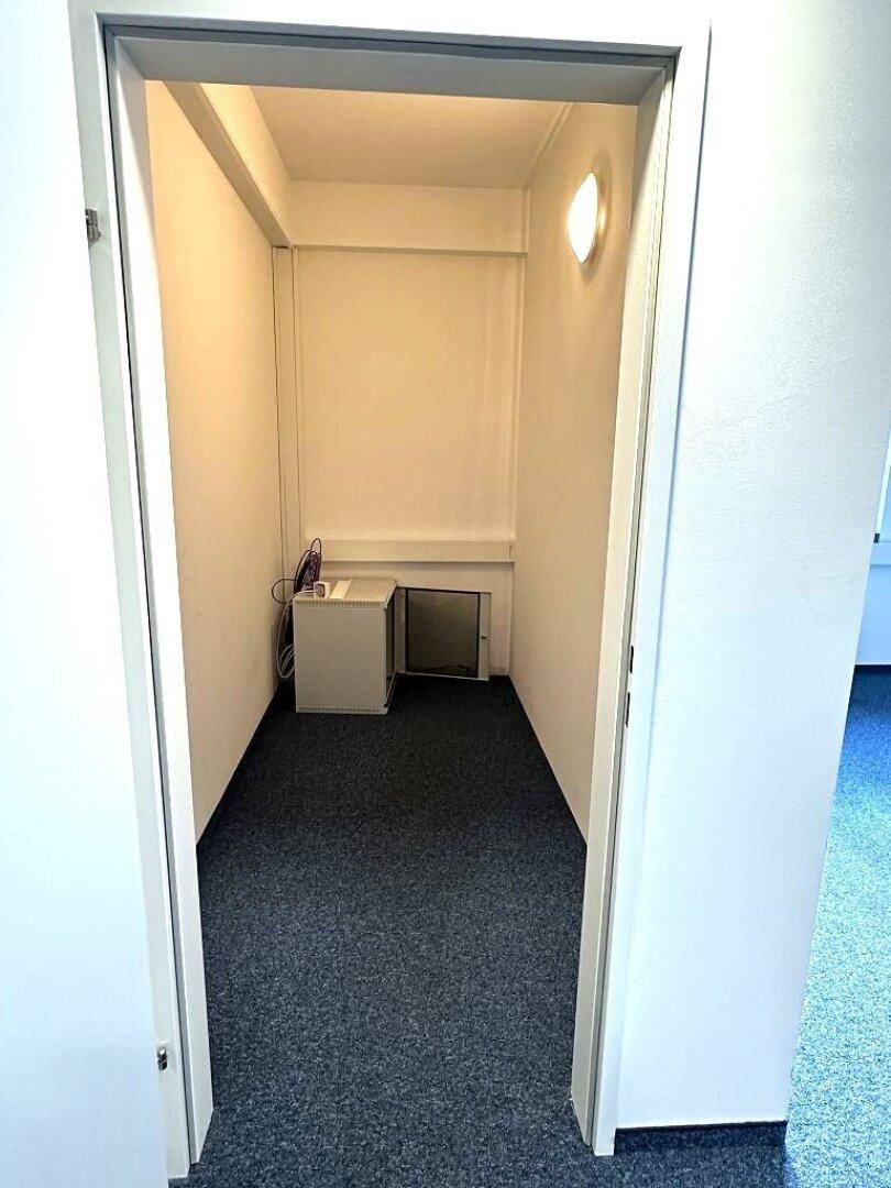 Kleiner Abstellraum mit Teppichboden und technischer Ausstattung, ideal für Server oder Lagerung.