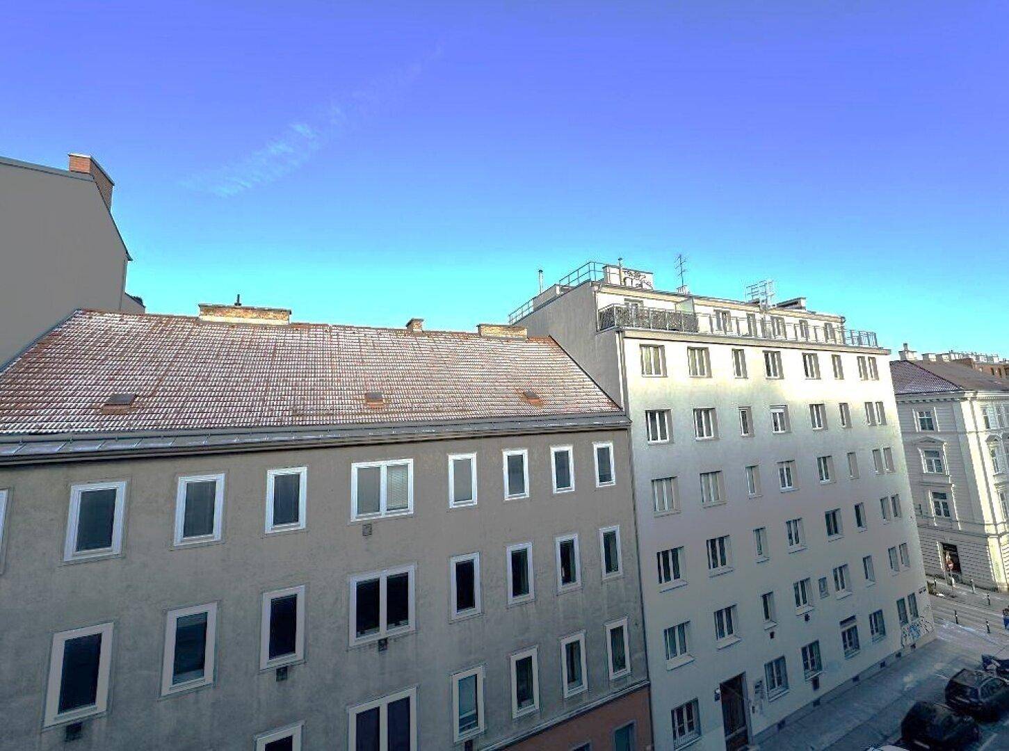 Ansicht von Gebäuden in einer städtischen Umgebung unter klarem blauem Himmel.