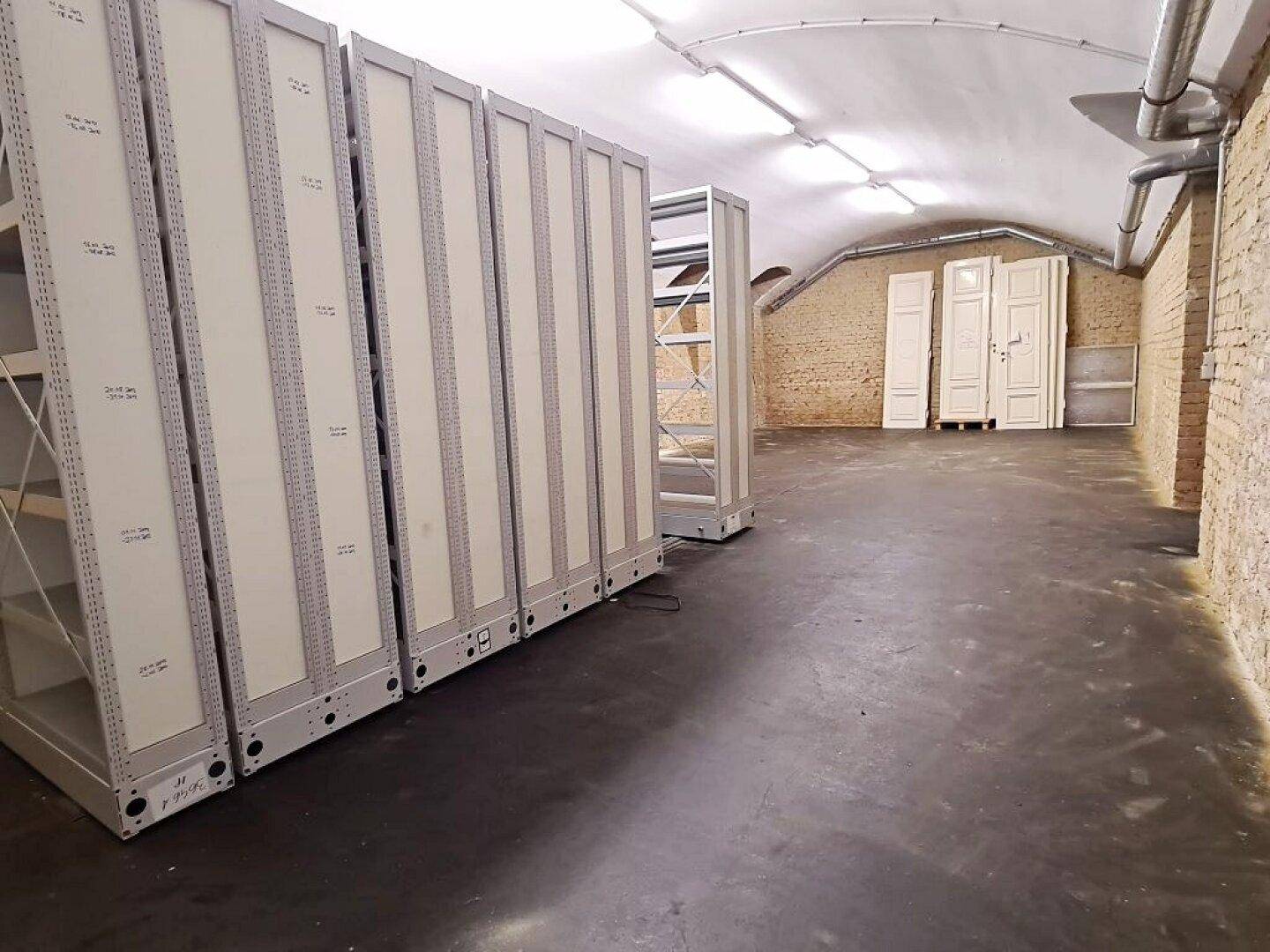 Ansicht der mobilen Regalsysteme in einem Kellerraum mit Ziegelwänden und Betonboden.