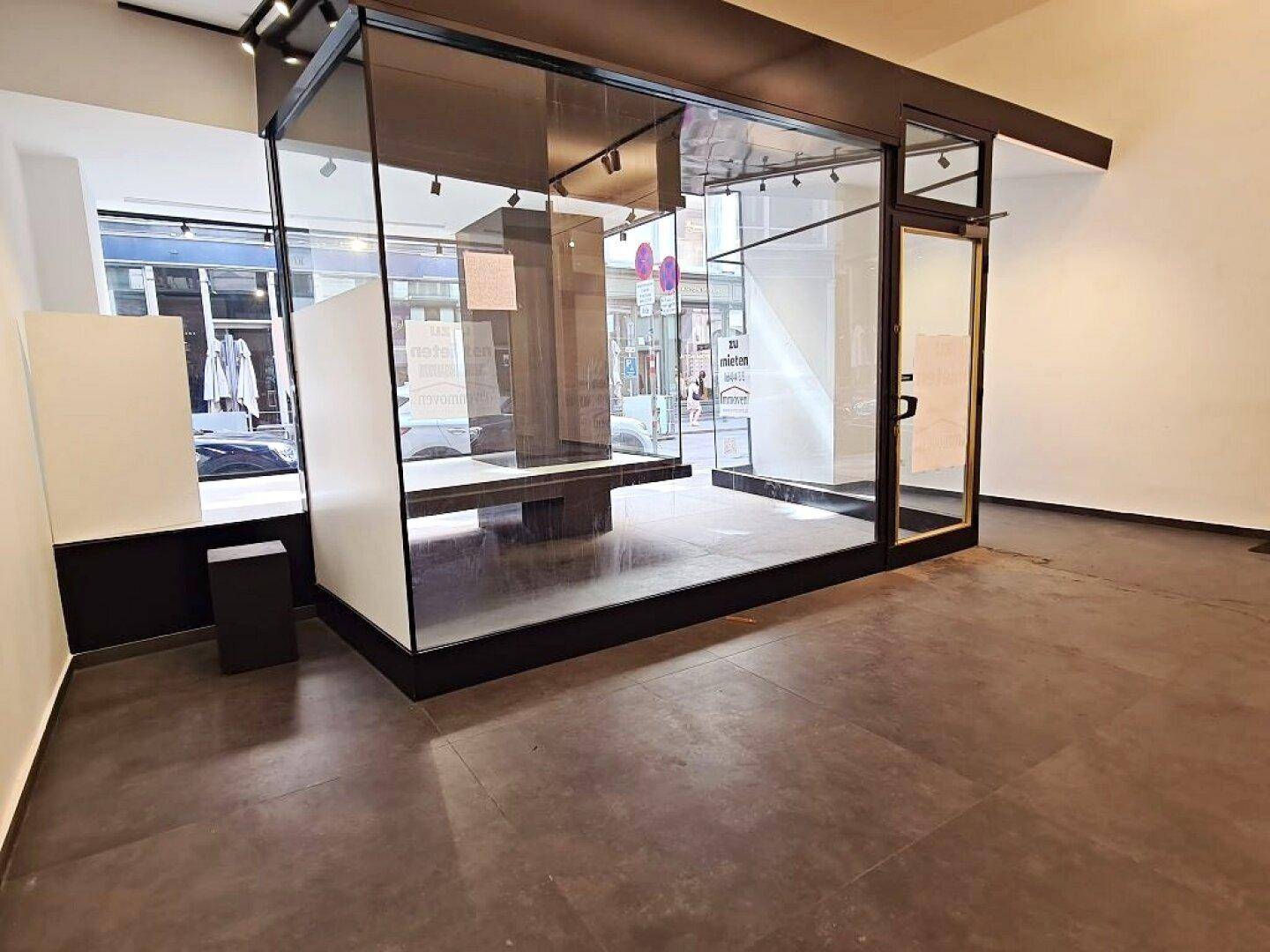Innenansicht eines Geschäftsraums mit Schaufenster und Ausstellungsflächen, bereit für Produktpräsentationen.