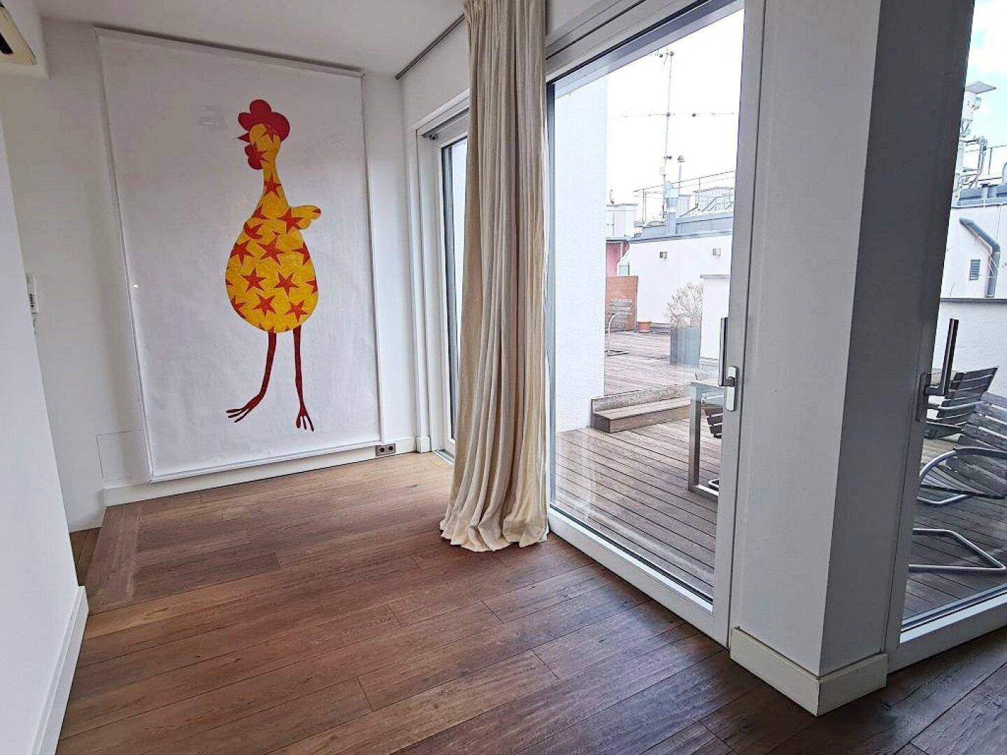 Heller Durchgangsbereich mit Holzboden und großen Glastüren zur Terrasse.