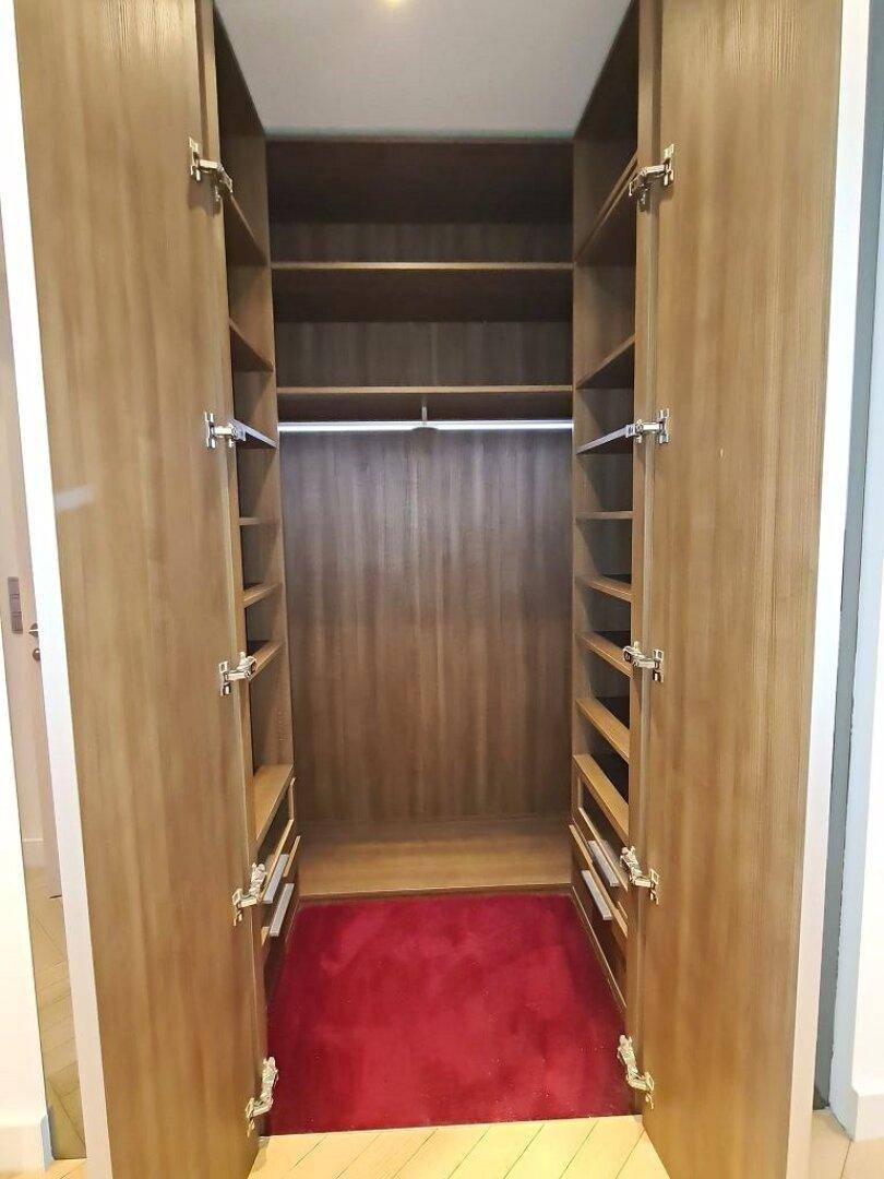Geräumiger Einbauschrank mit Regalen und Kleiderstange, ideal für organisierte Aufbewahrung.
