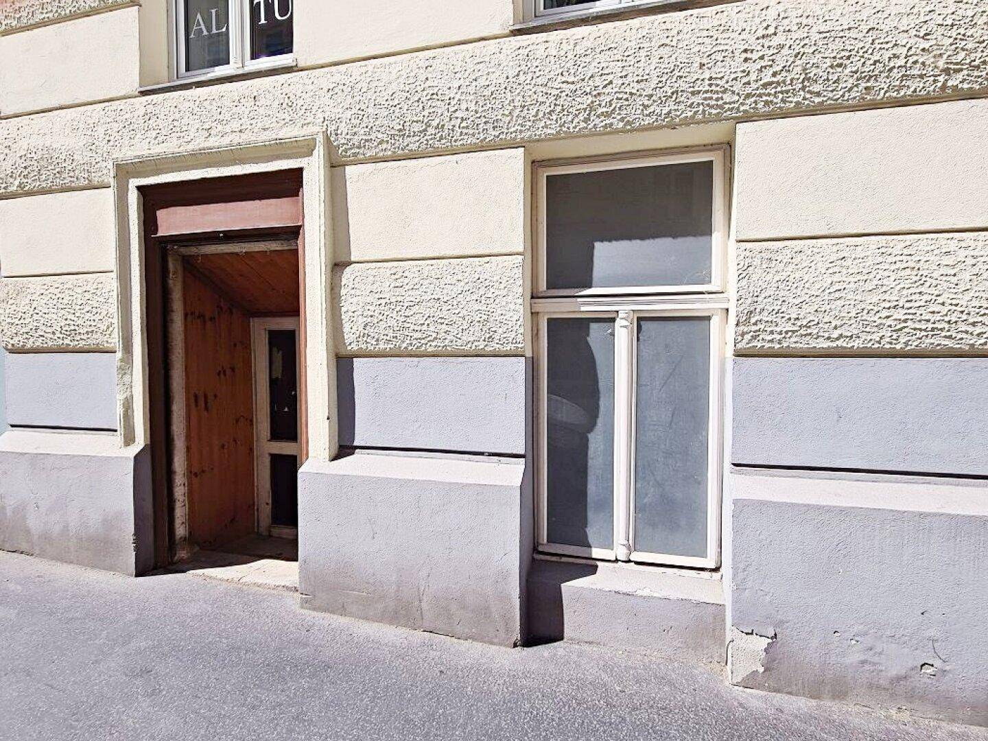 Nahaufnahme des Gebäudeeingangs und eines Fensters auf Straßenniveau.