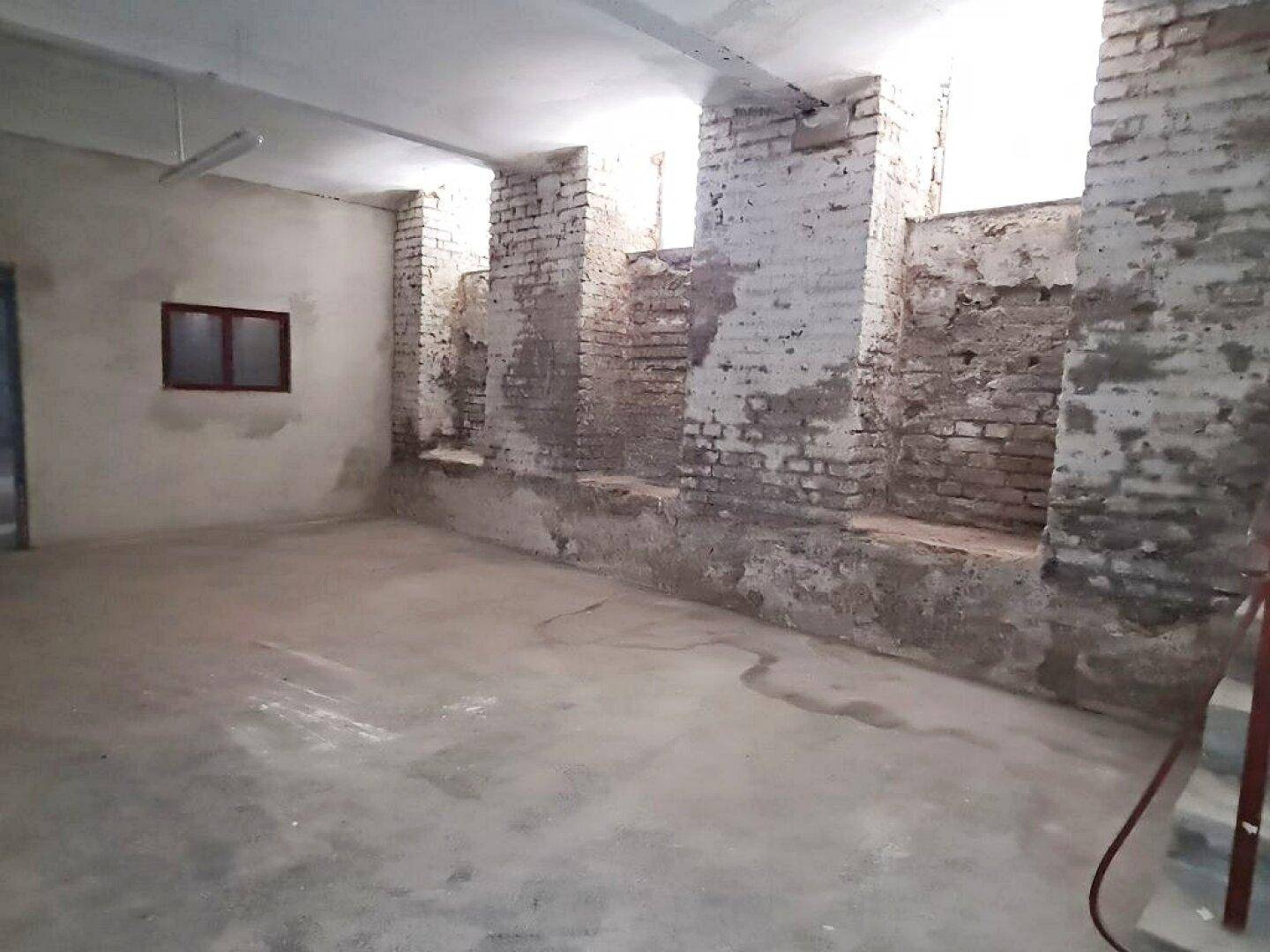 Großer Kellerraum mit rohen Ziegelwänden, Betonboden und sichtbaren Spuren der Zeit, bereit zur Renovierung.