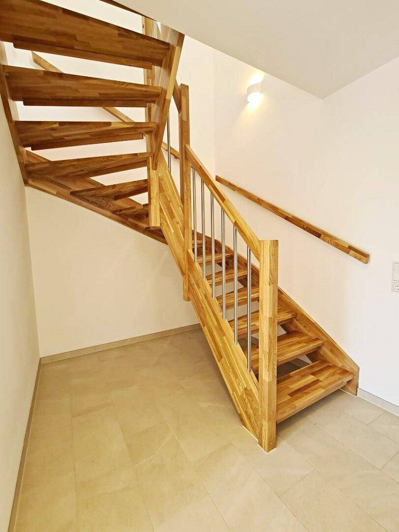 Moderne Holztreppe mit Metallgeländer, die die Etagen des Hauses verbindet.