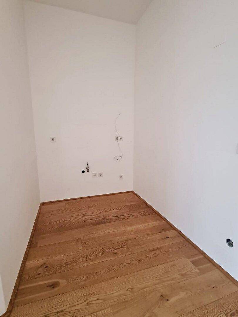 Kleiner Raum mit Holzboden und weißen Wänden, ideal als Abstellraum oder für Installationen.