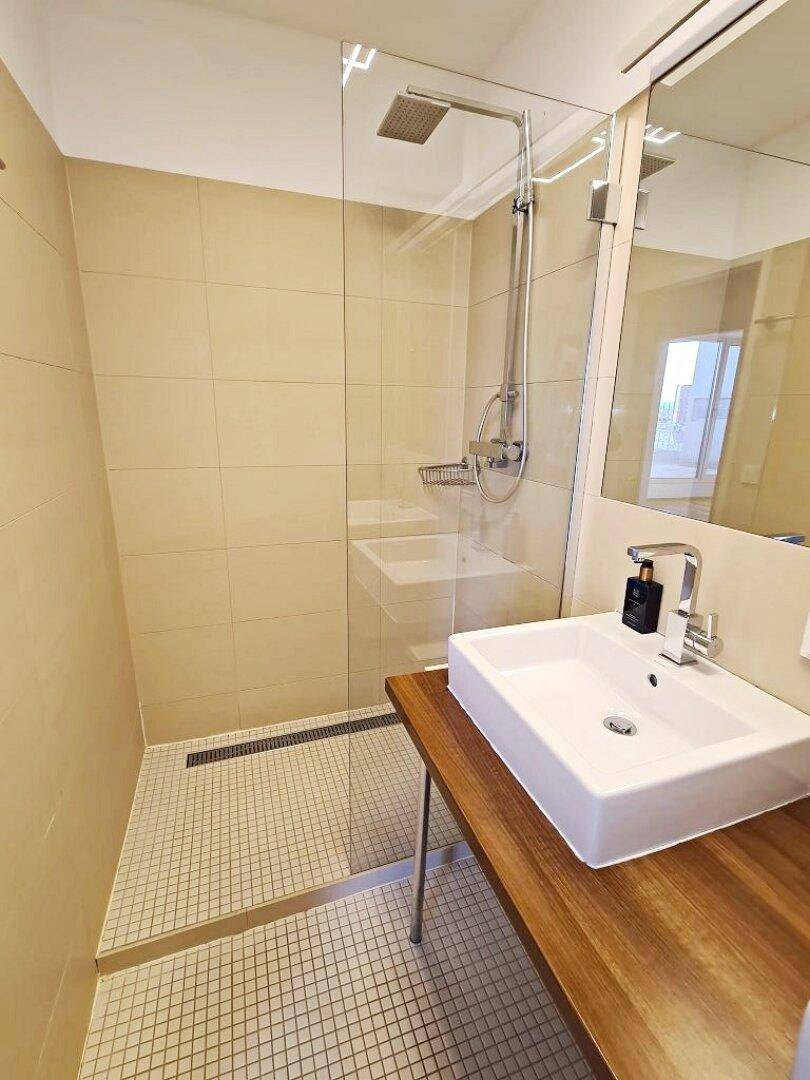 Geräumige begehbare Dusche mit Glaswand und modernen Armaturen im Badezimmer.